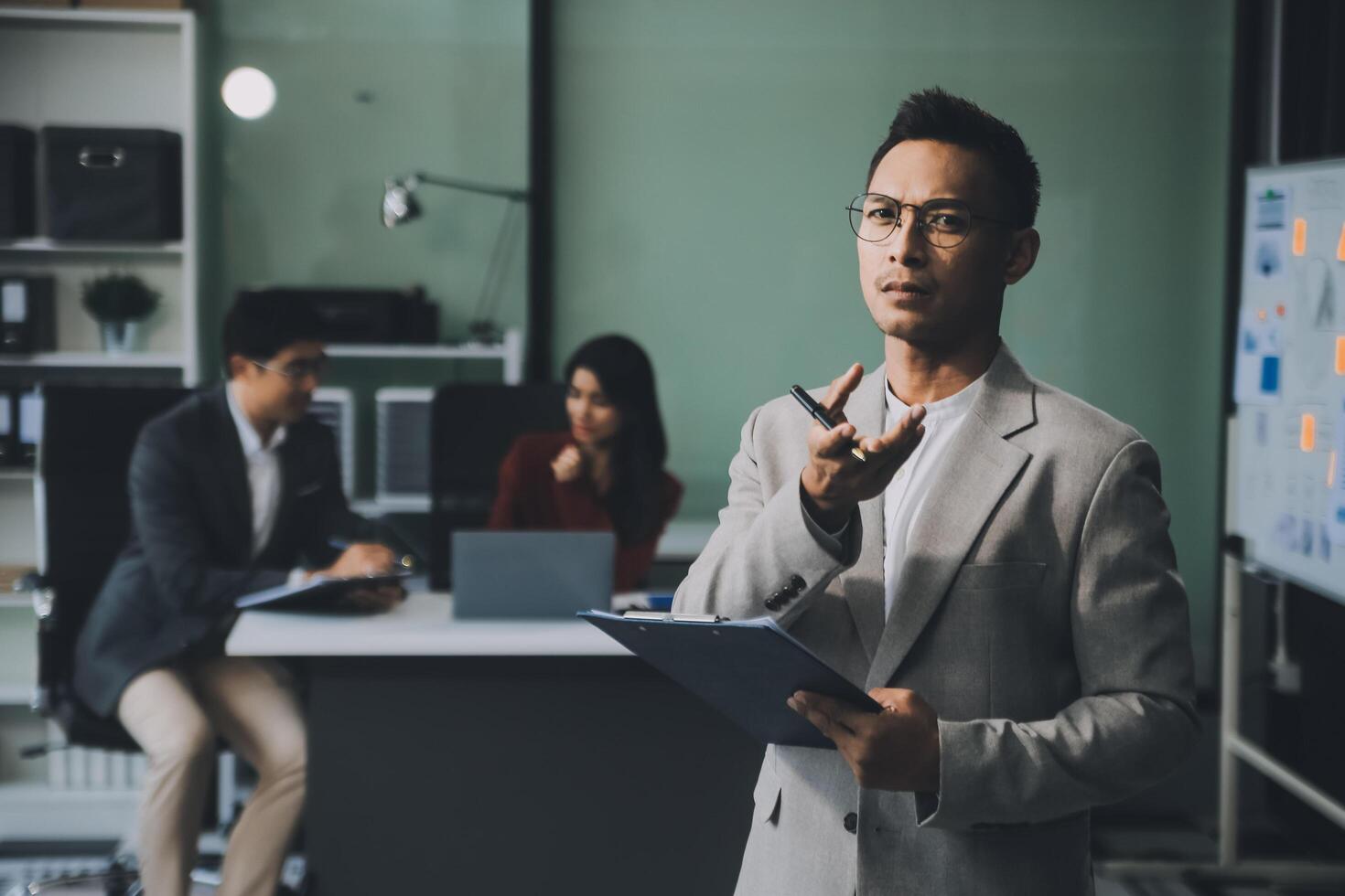 Group of colleagues engaging in a discussion during a business meeting in a conference room. Happy business people, men and women, collaborating and working towards their shared goals. photo