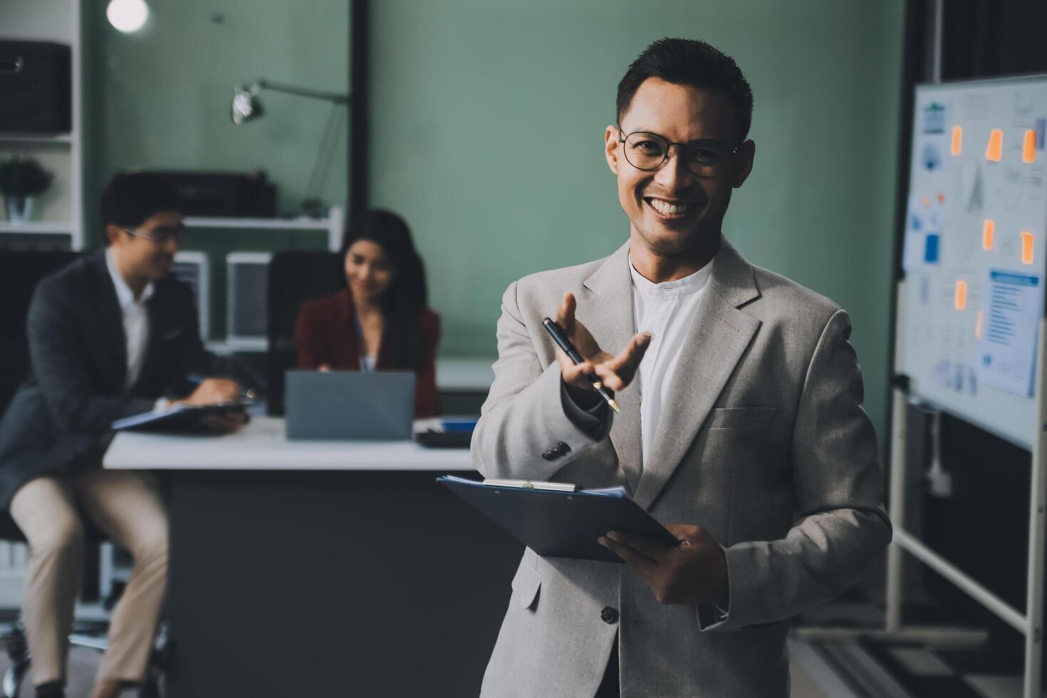 Group of colleagues engaging in a discussion during a business meeting in a conference room. Happy business people, men and women, collaborating and working towards their shared goals. photo