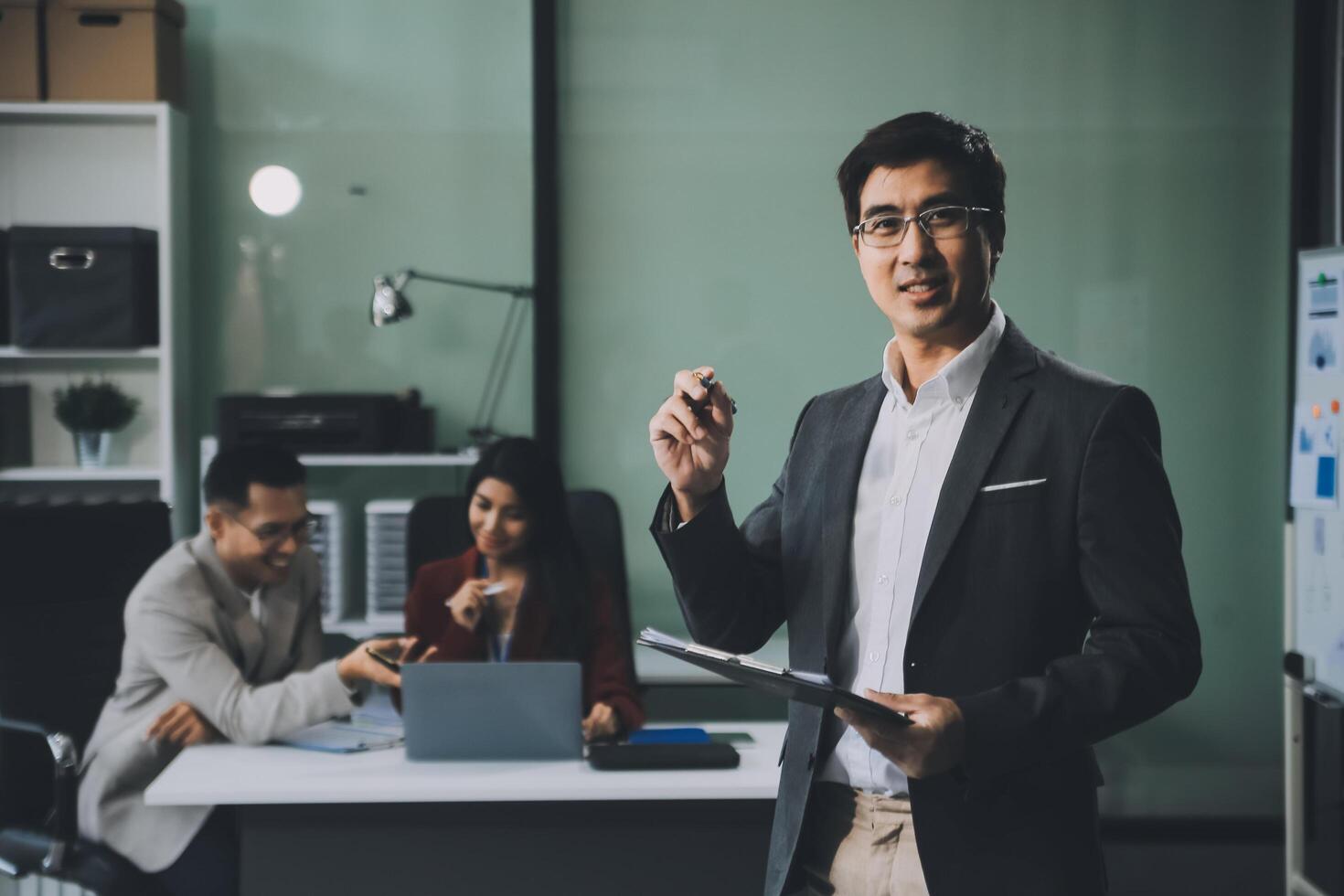 Group of colleagues engaging in a discussion during a business meeting in a conference room. Happy business people, men and women, collaborating and working towards their shared goals. photo