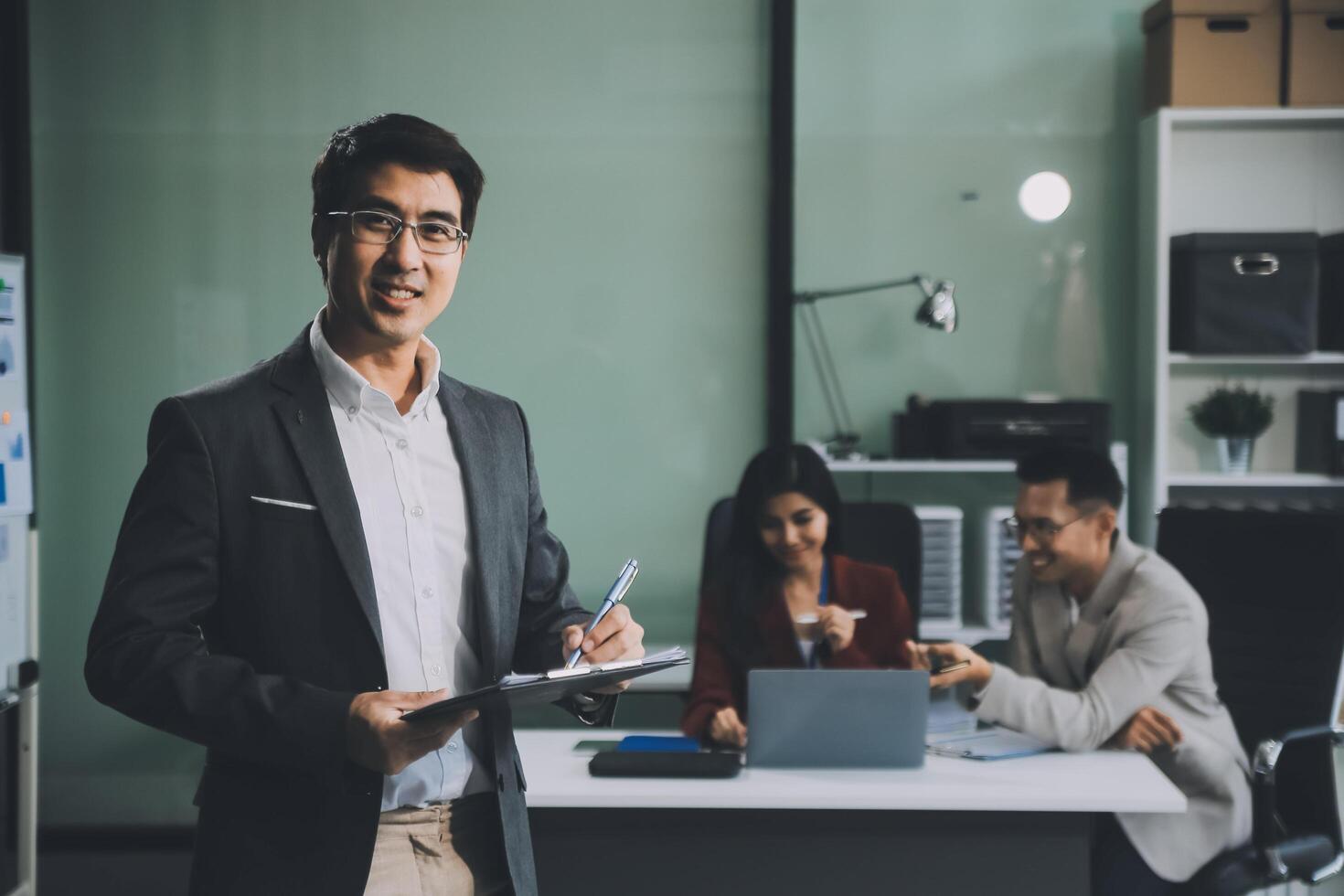 Group of colleagues engaging in a discussion during a business meeting in a conference room. Happy business people, men and women, collaborating and working towards their shared goals. photo