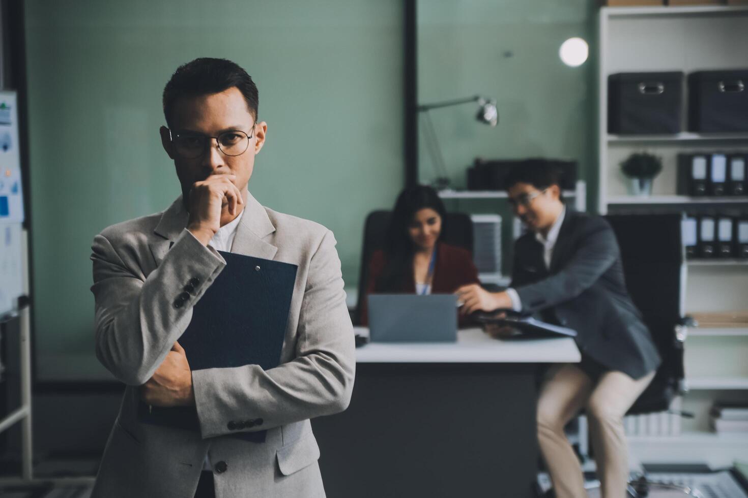 Group of colleagues engaging in a discussion during a business meeting in a conference room. Happy business people, men and women, collaborating and working towards their shared goals. photo
