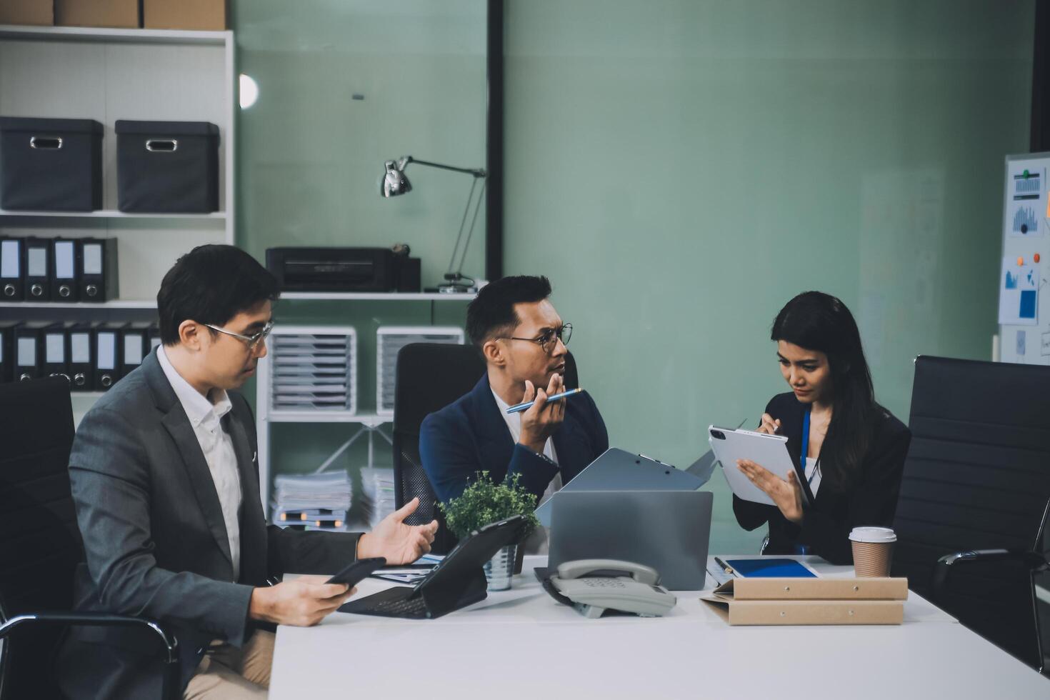 Group of colleagues engaging in a discussion during a business meeting in a conference room. Happy business people, men and women, collaborating and working towards their shared goals. photo