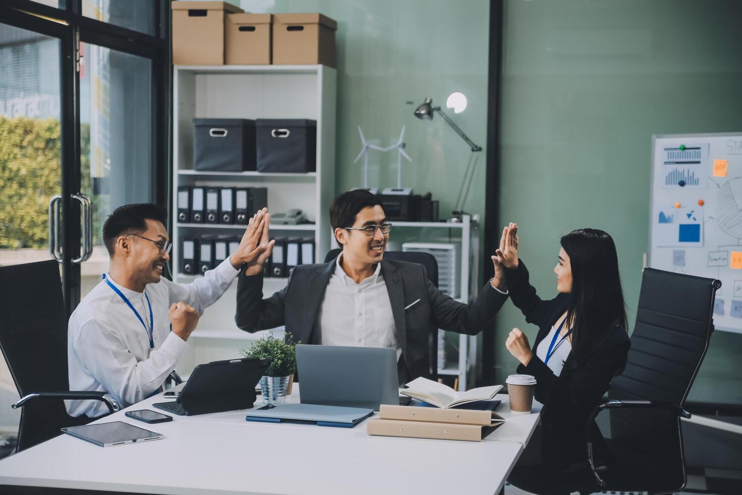 Group of colleagues engaging in a discussion during a business meeting in a conference room. Happy business people, men and women, collaborating and working towards their shared goals. photo