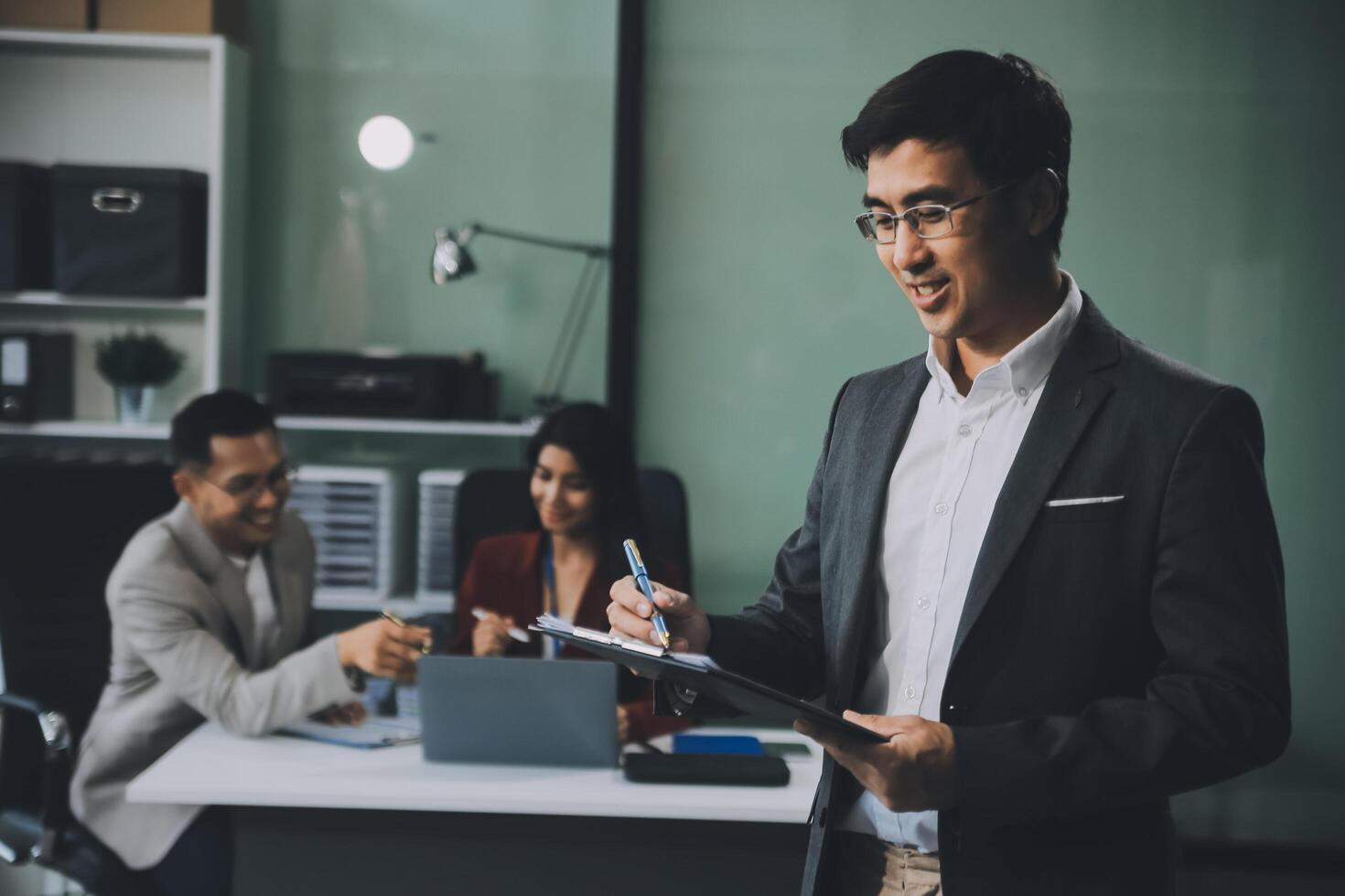 Group of colleagues engaging in a discussion during a business meeting in a conference room. Happy business people, men and women, collaborating and working towards their shared goals. photo