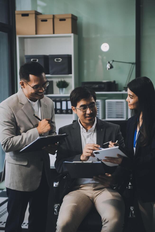 Group of colleagues engaging in a discussion during a business meeting in a conference room. Happy business people, men and women, collaborating and working towards their shared goals. photo