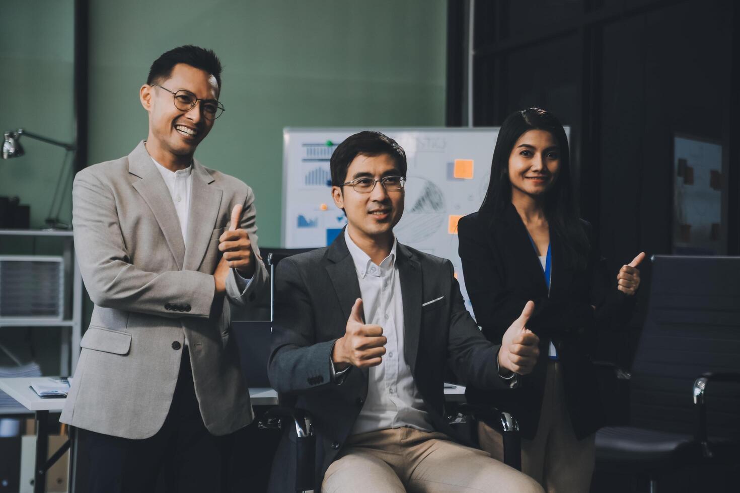 Group of colleagues engaging in a discussion during a business meeting in a conference room. Happy business people, men and women, collaborating and working towards their shared goals. photo