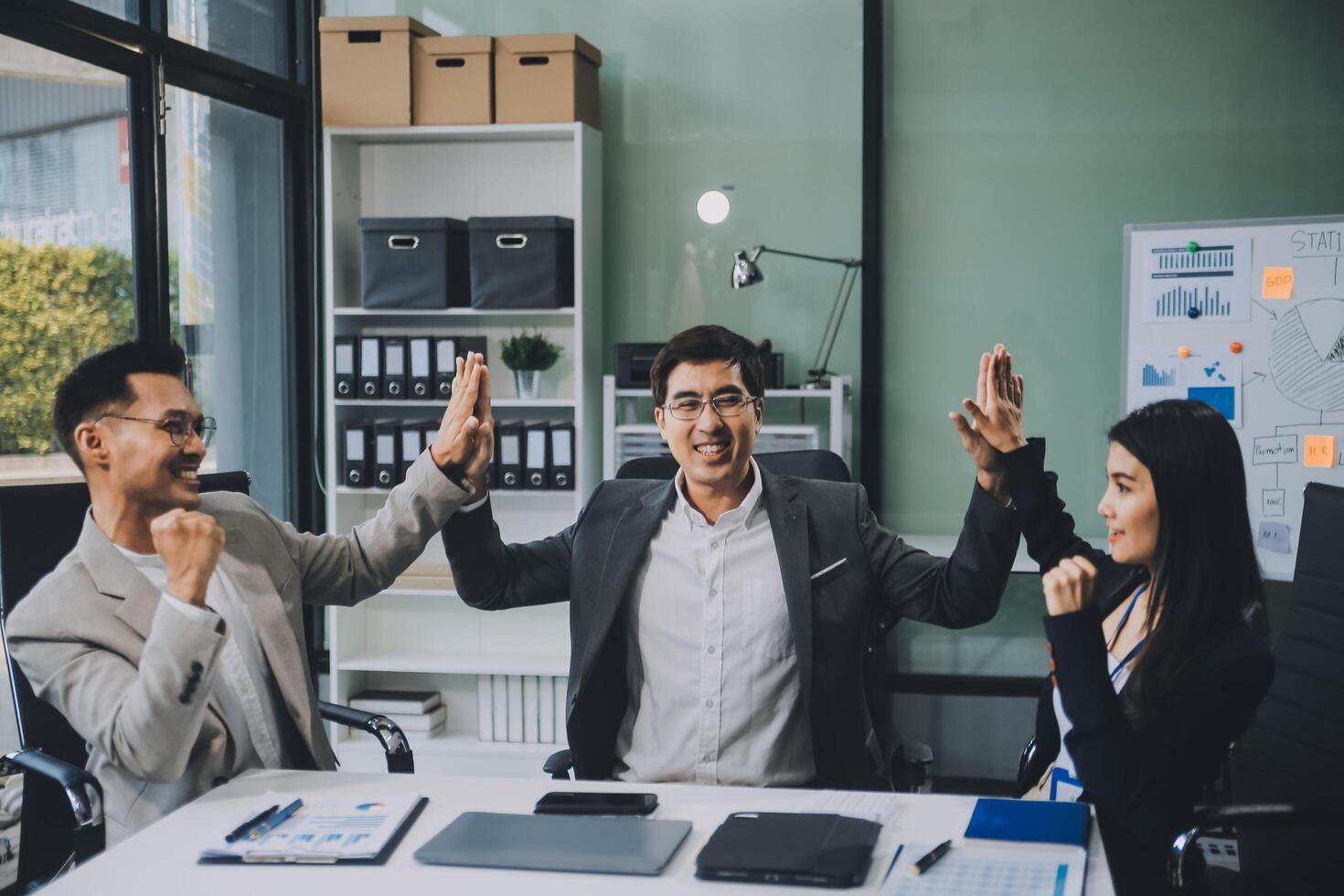 Group of colleagues engaging in a discussion during a business meeting in a conference room. Happy business people, men and women, collaborating and working towards their shared goals. photo