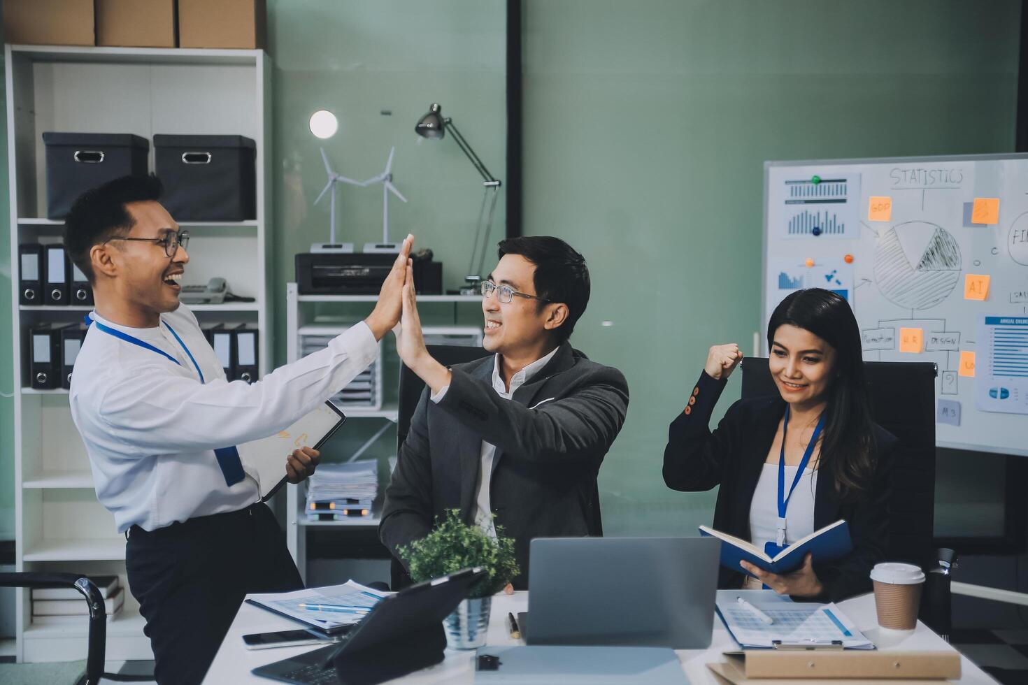 Group of colleagues engaging in a discussion during a business meeting in a conference room. Happy business people, men and women, collaborating and working towards their shared goals. photo