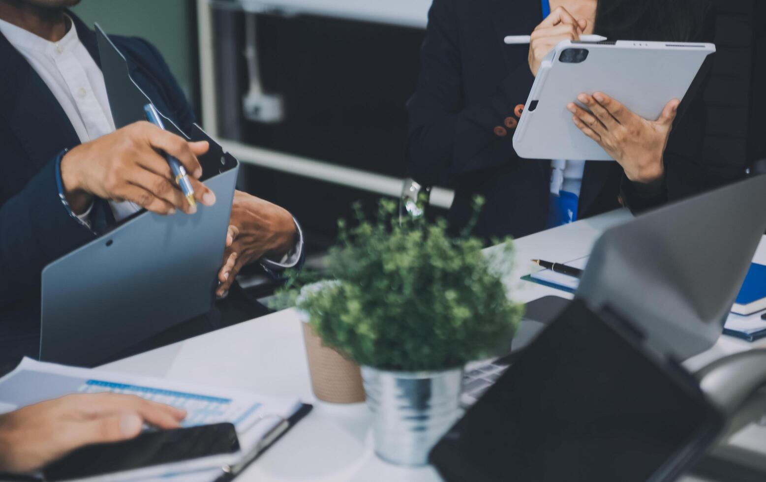 Group of colleagues engaging in a discussion during a business meeting in a conference room. Happy business people, men and women, collaborating and working towards their shared goals. photo