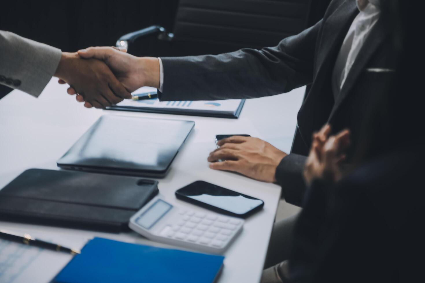 Group of colleagues engaging in a discussion during a business meeting in a conference room. Happy business people, men and women, collaborating and working towards their shared goals. photo