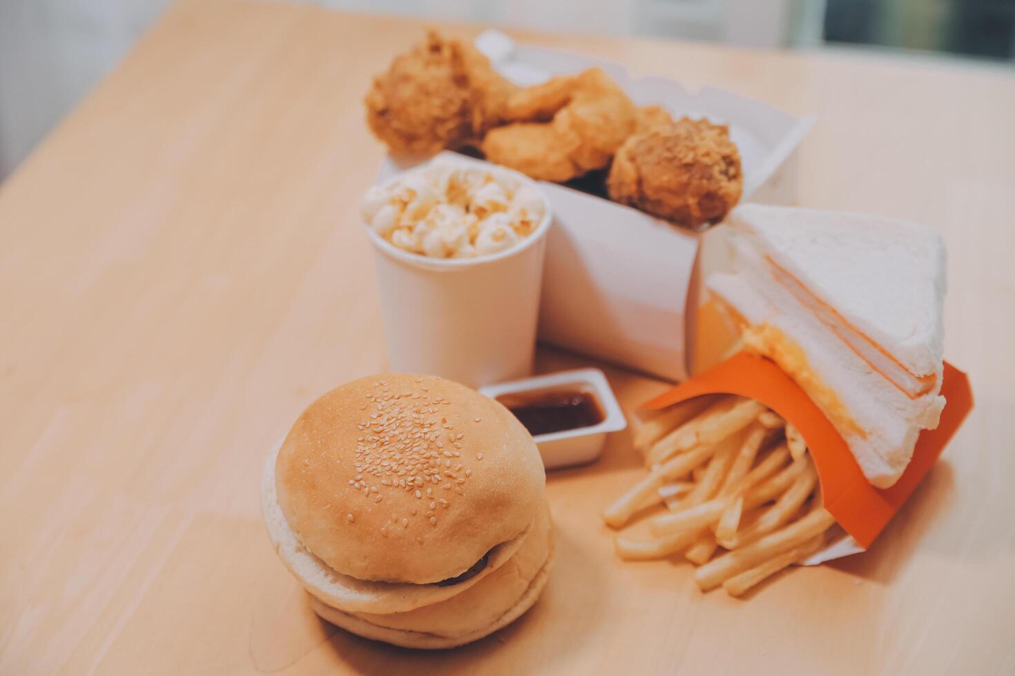 fast food, people and unhealthy eating concept - close up of woman hands holding hamburger or cheeseburger photo