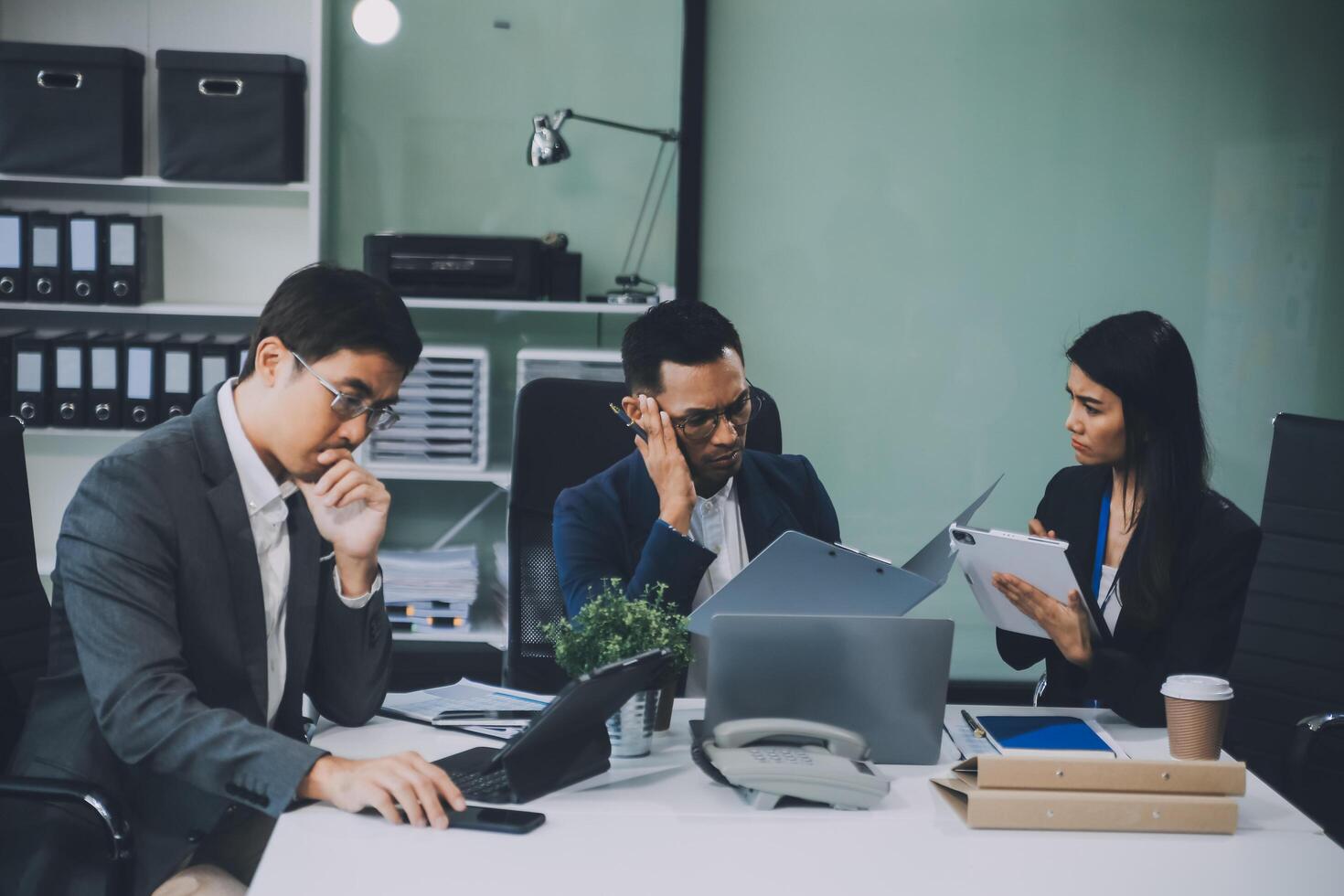 Group of colleagues engaging in a discussion during a business meeting in a conference room. Happy business people, men and women, collaborating and working towards their shared goals. photo