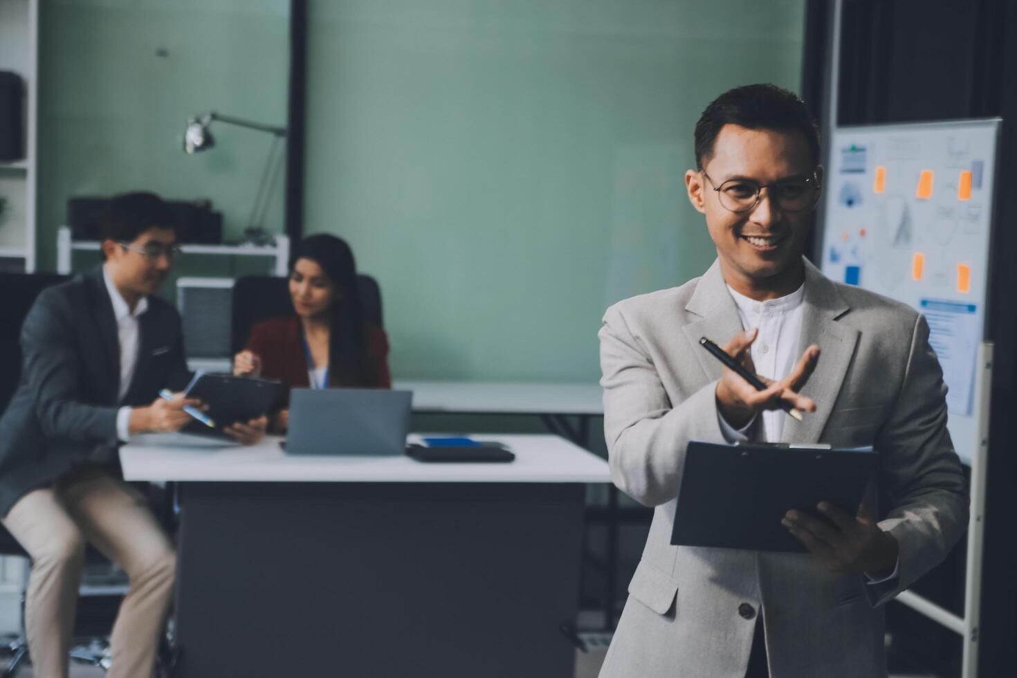 Group of colleagues engaging in a discussion during a business meeting in a conference room. Happy business people, men and women, collaborating and working towards their shared goals. photo