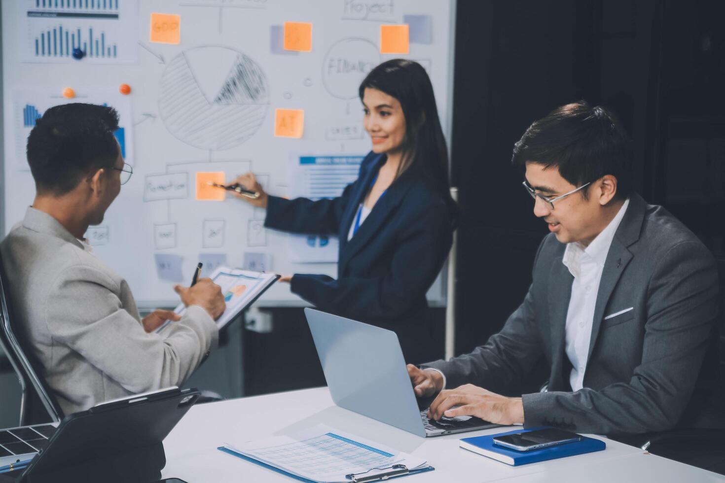 Group of confident business people point to graphs and charts to analyze market data, balance sheet, account, net profit to plan new sales strategies to increase production capacity. photo