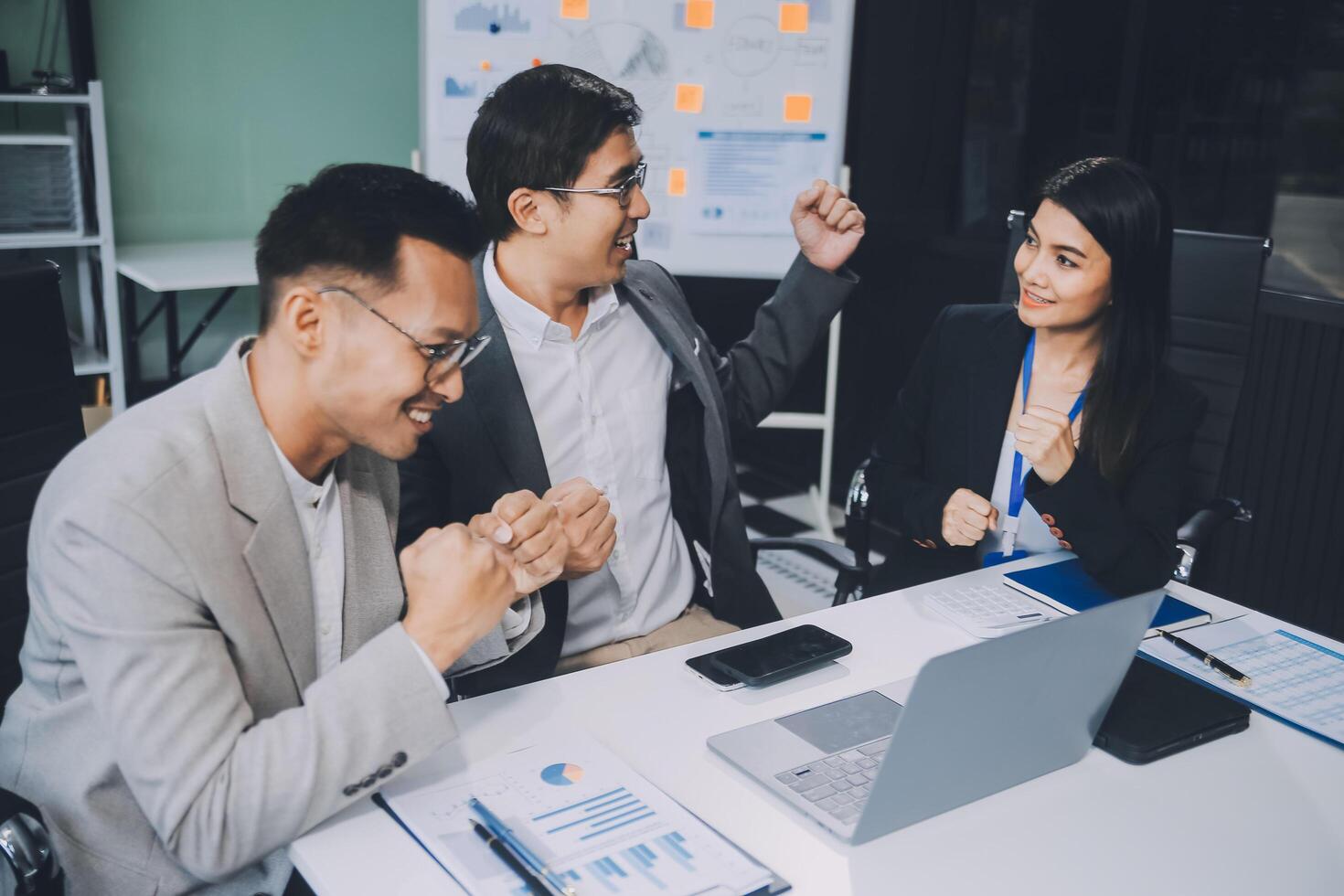 Group of colleagues engaging in a discussion during a business meeting in a conference room. Happy business people, men and women, collaborating and working towards their shared goals. photo