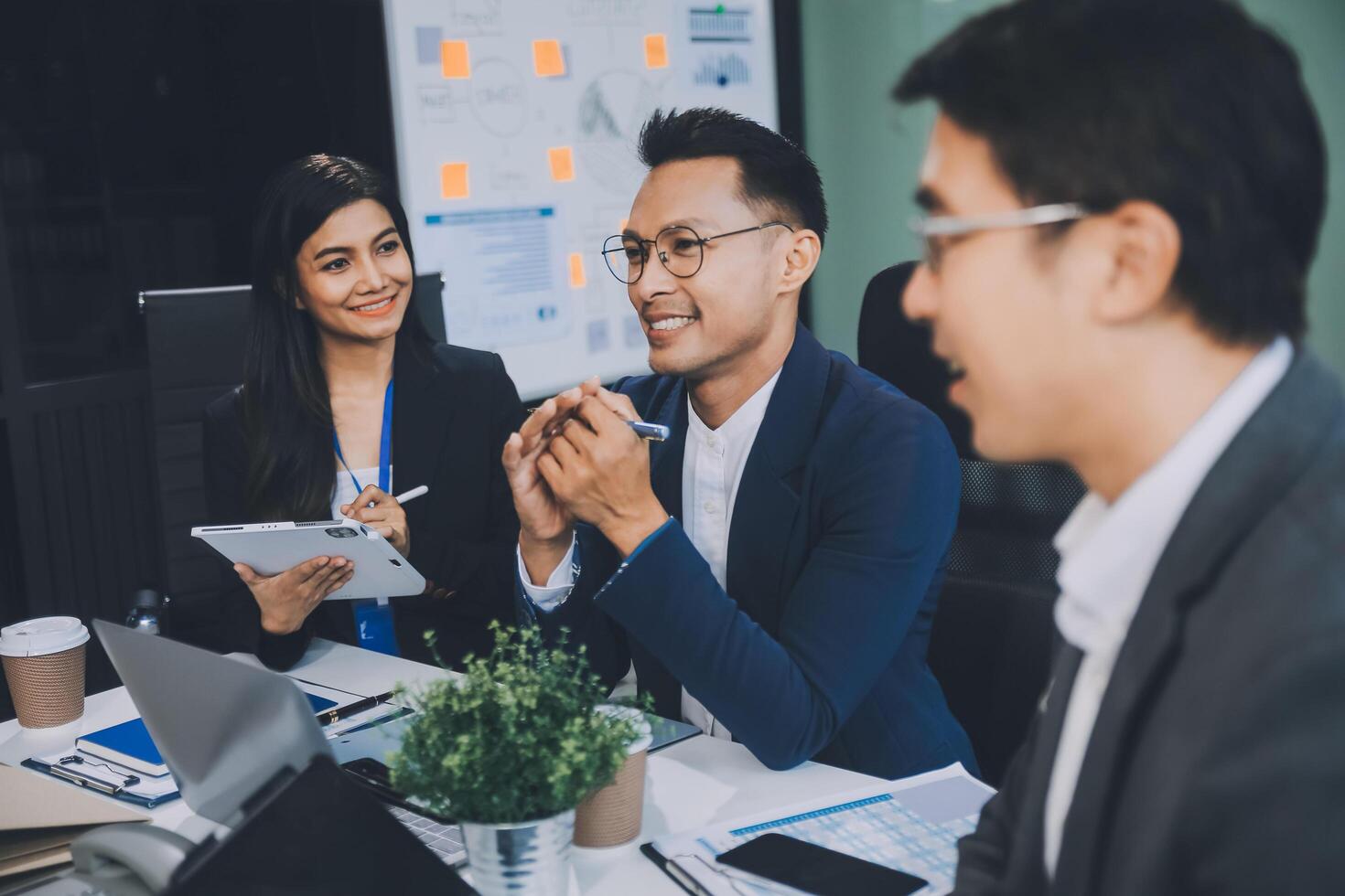 Group of colleagues engaging in a discussion during a business meeting in a conference room. Happy business people, men and women, collaborating and working towards their shared goals. photo