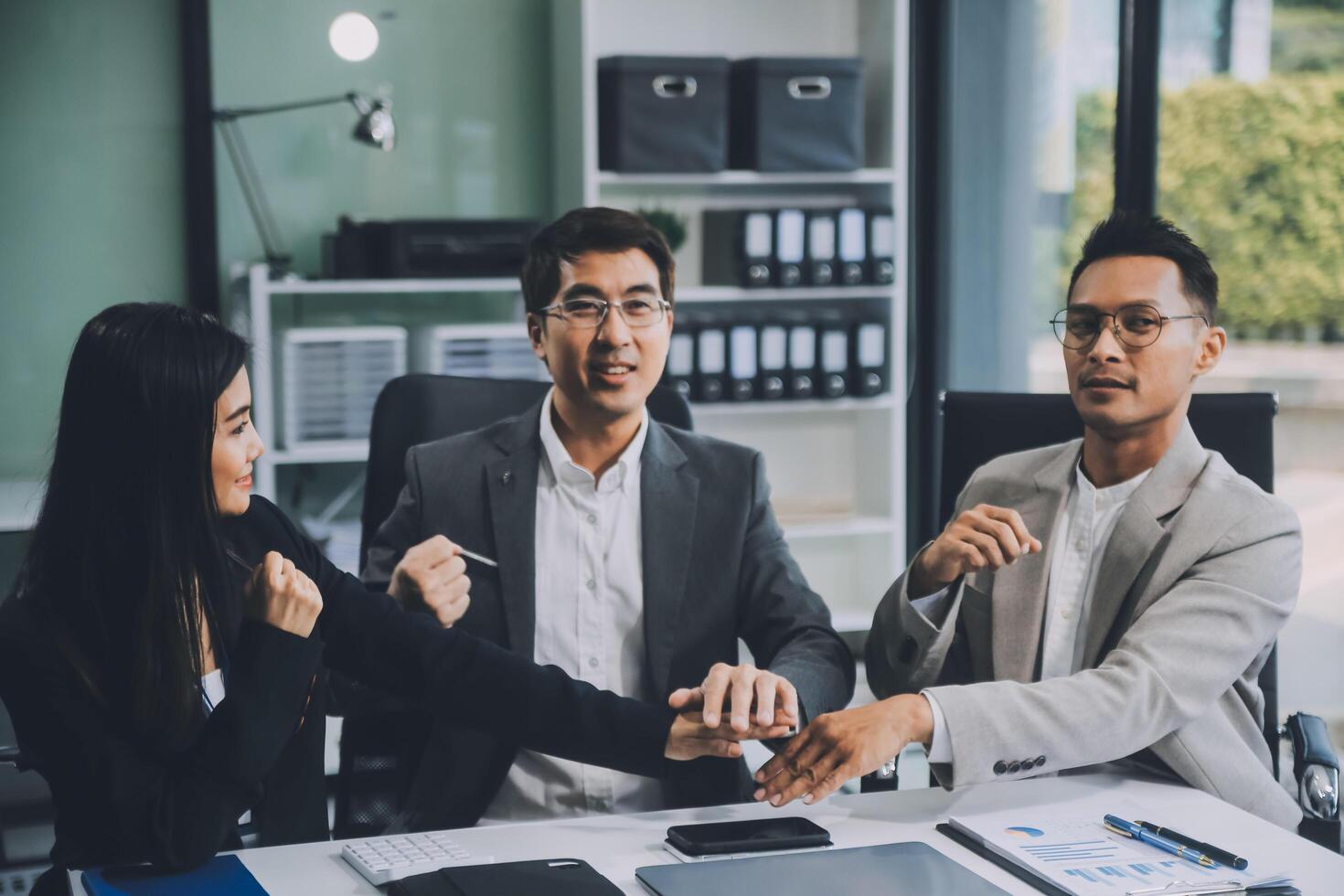Group of colleagues engaging in a discussion during a business meeting in a conference room. Happy business people, men and women, collaborating and working towards their shared goals. photo