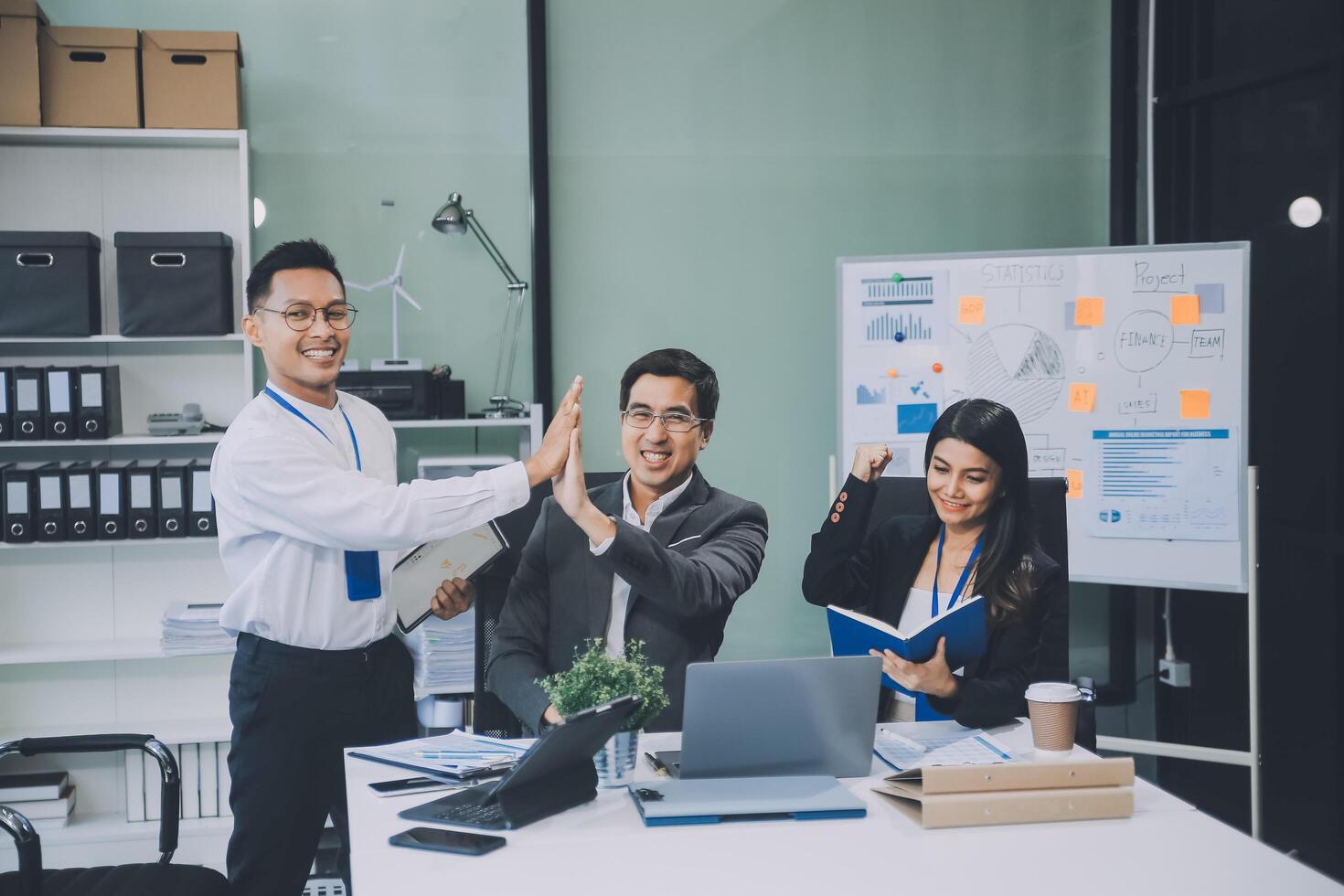 Group of colleagues engaging in a discussion during a business meeting in a conference room. Happy business people, men and women, collaborating and working towards their shared goals. photo