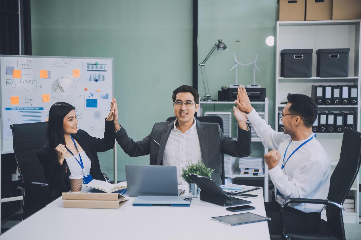 Group of colleagues engaging in a discussion during a business meeting in a conference room. Happy business people, men and women, collaborating and working towards their shared goals. photo