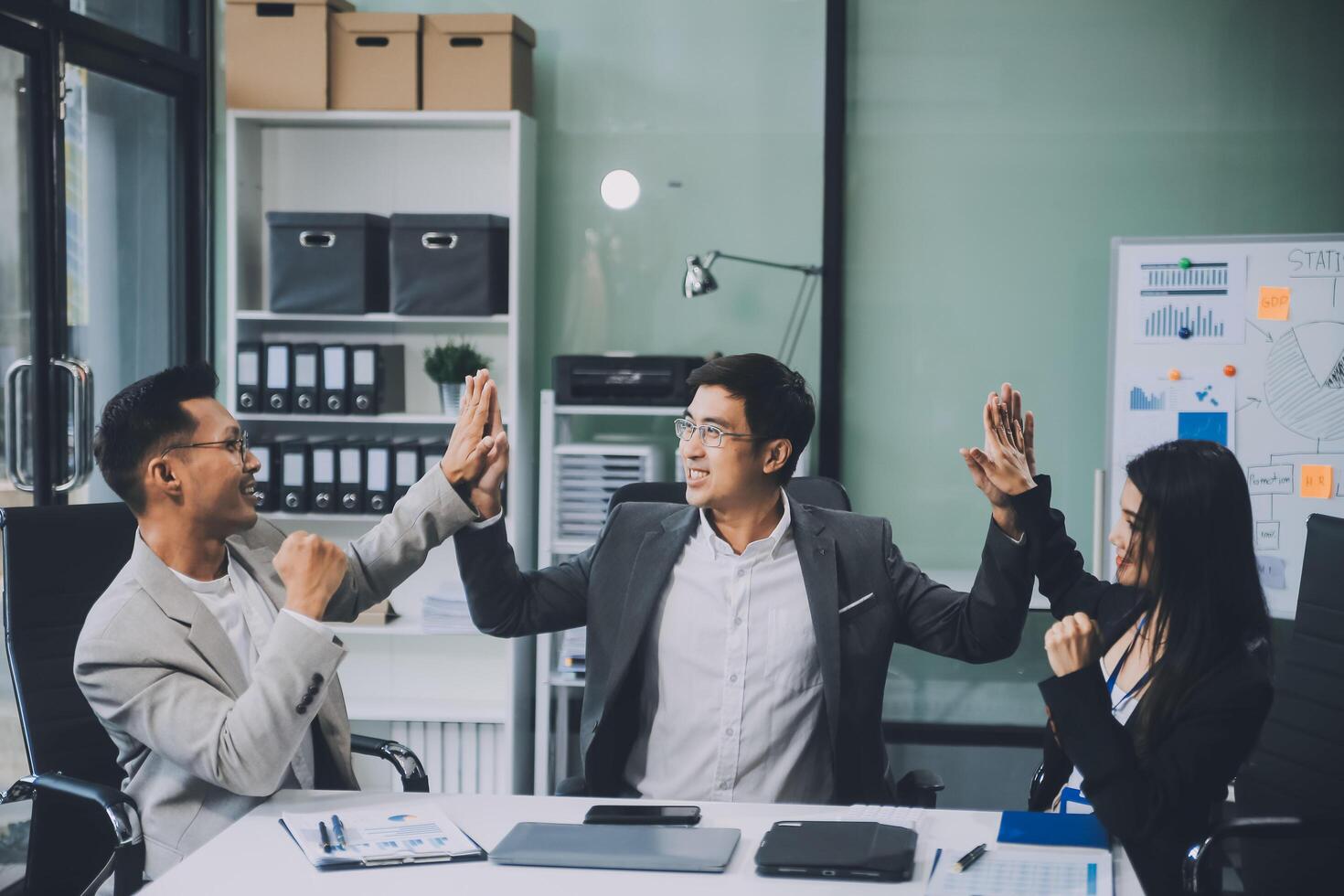Group of colleagues engaging in a discussion during a business meeting in a conference room. Happy business people, men and women, collaborating and working towards their shared goals. photo