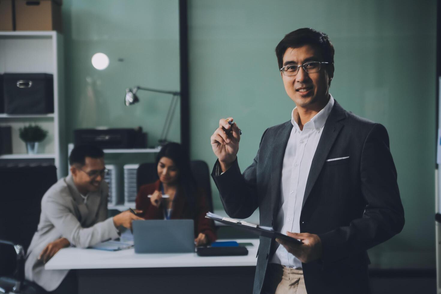 Group of colleagues engaging in a discussion during a business meeting in a conference room. Happy business people, men and women, collaborating and working towards their shared goals. photo