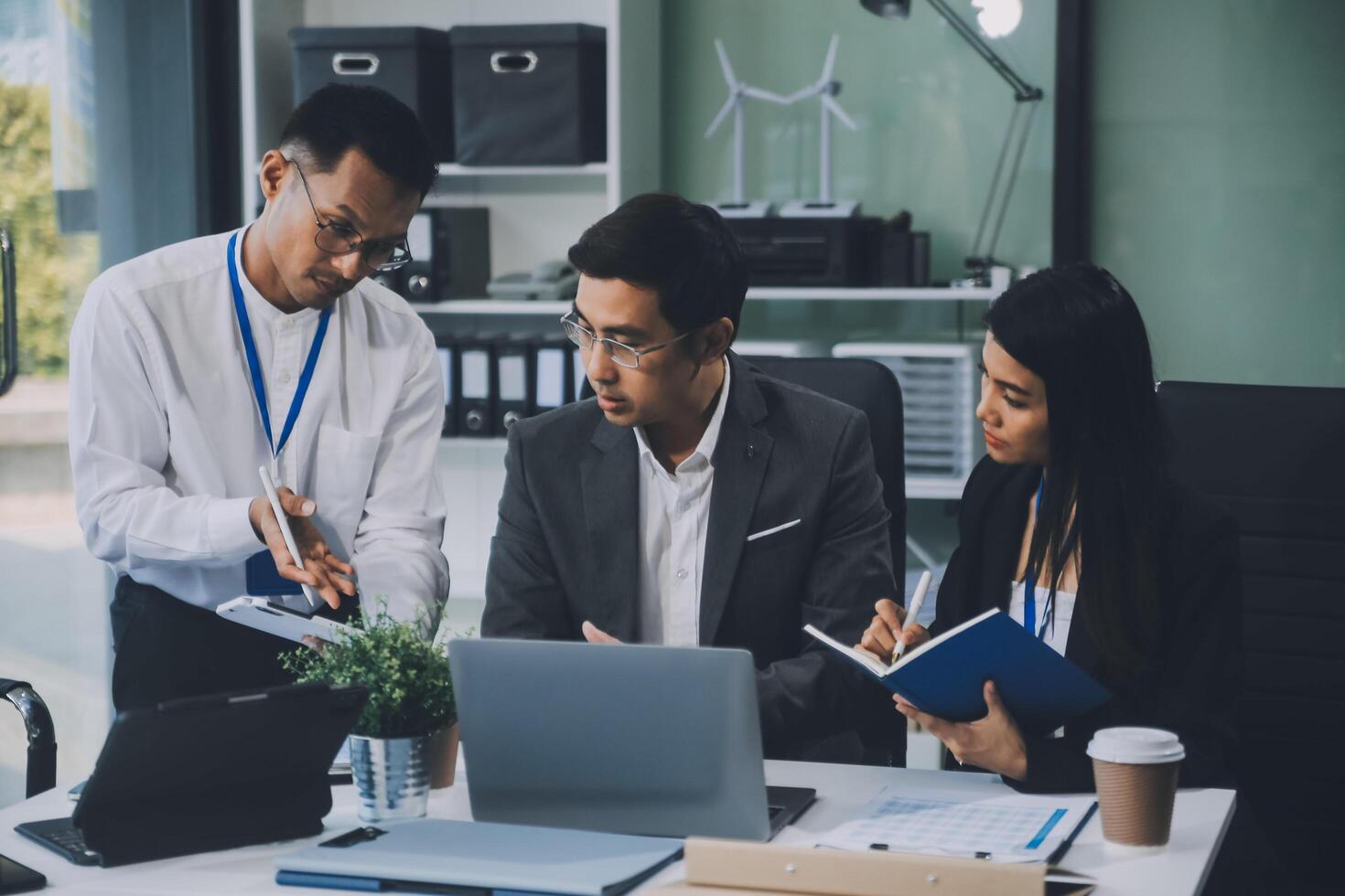 Group of colleagues engaging in a discussion during a business meeting in a conference room. Happy business people, men and women, collaborating and working towards their shared goals. photo