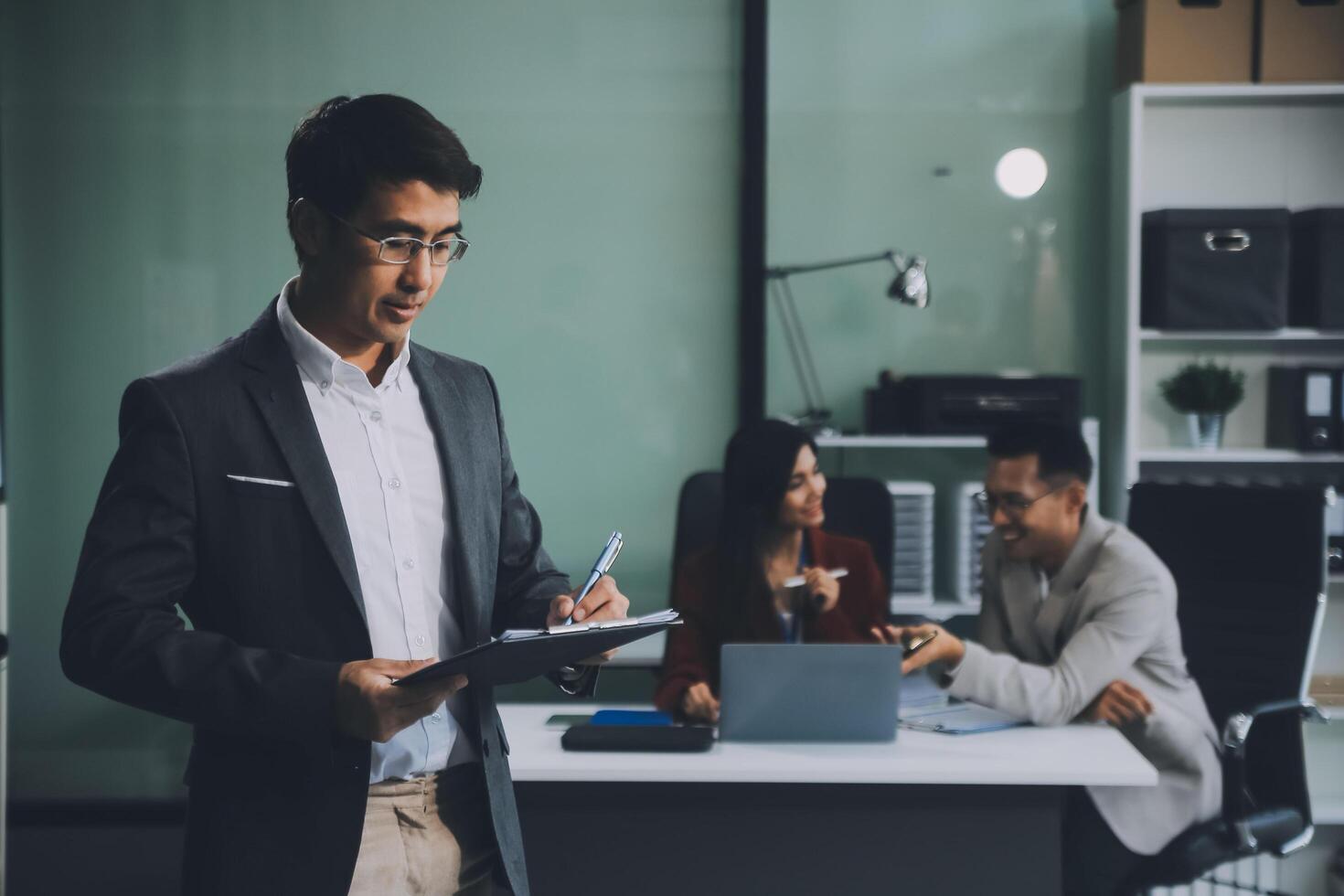 Group of colleagues engaging in a discussion during a business meeting in a conference room. Happy business people, men and women, collaborating and working towards their shared goals. photo