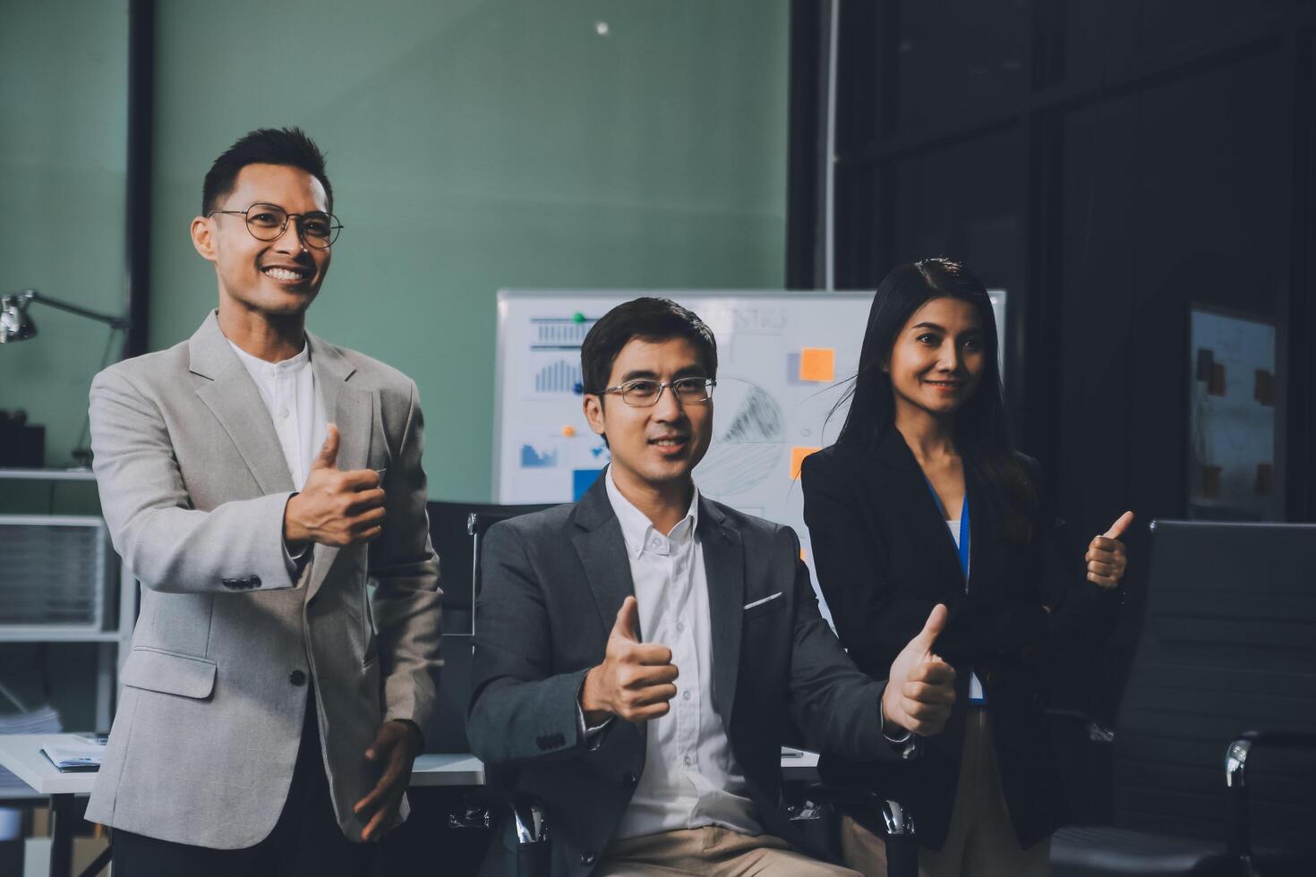 Group of colleagues engaging in a discussion during a business meeting in a conference room. Happy business people, men and women, collaborating and working towards their shared goals. photo