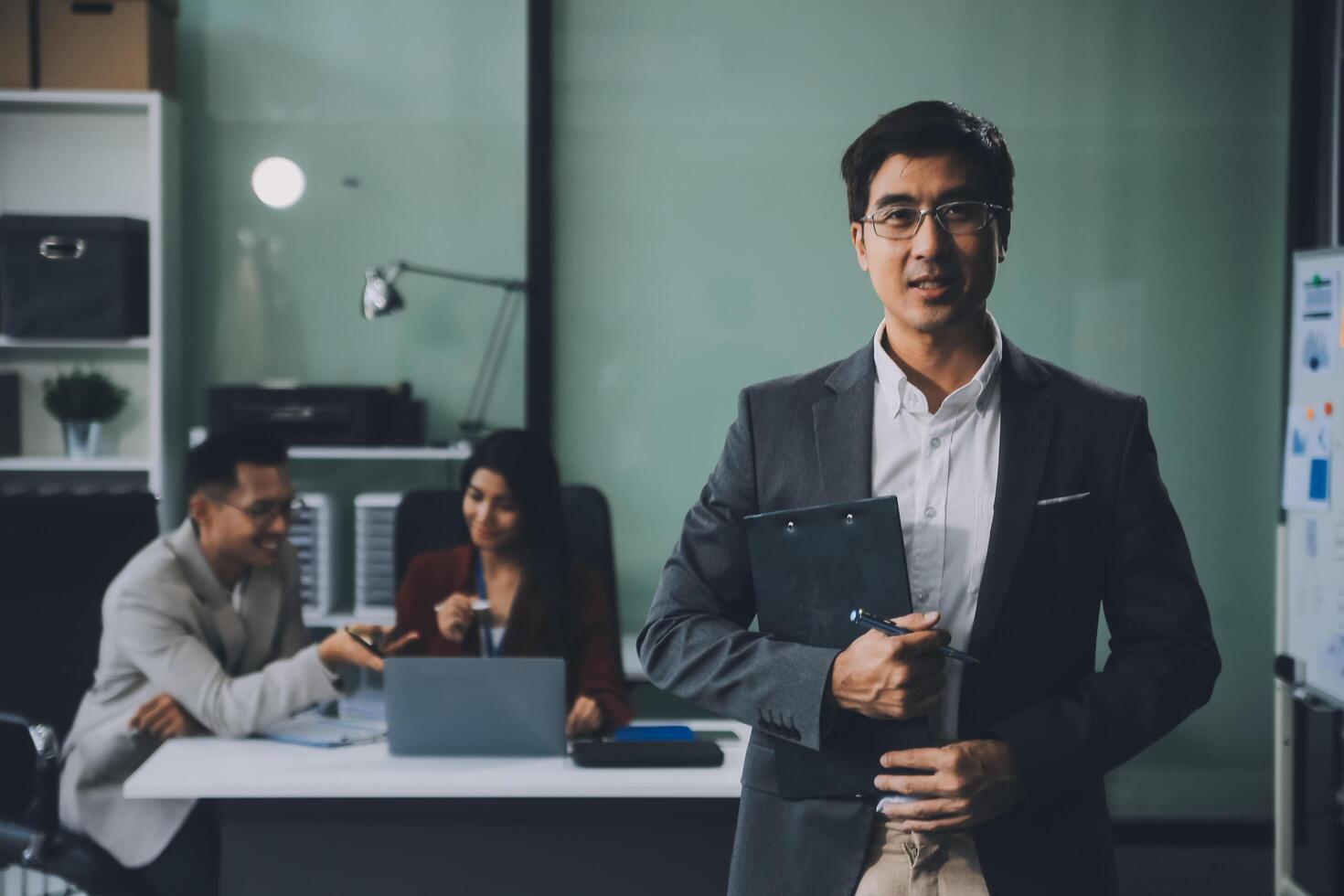 Group of colleagues engaging in a discussion during a business meeting in a conference room. Happy business people, men and women, collaborating and working towards their shared goals. photo