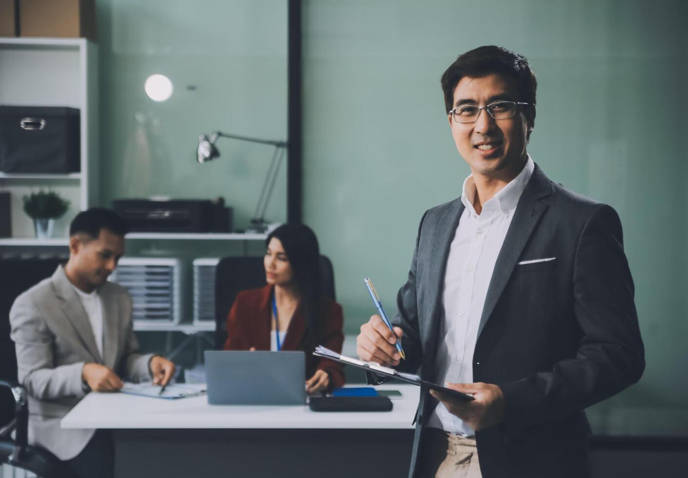 Group of colleagues engaging in a discussion during a business meeting in a conference room. Happy business people, men and women, collaborating and working towards their shared goals. photo
