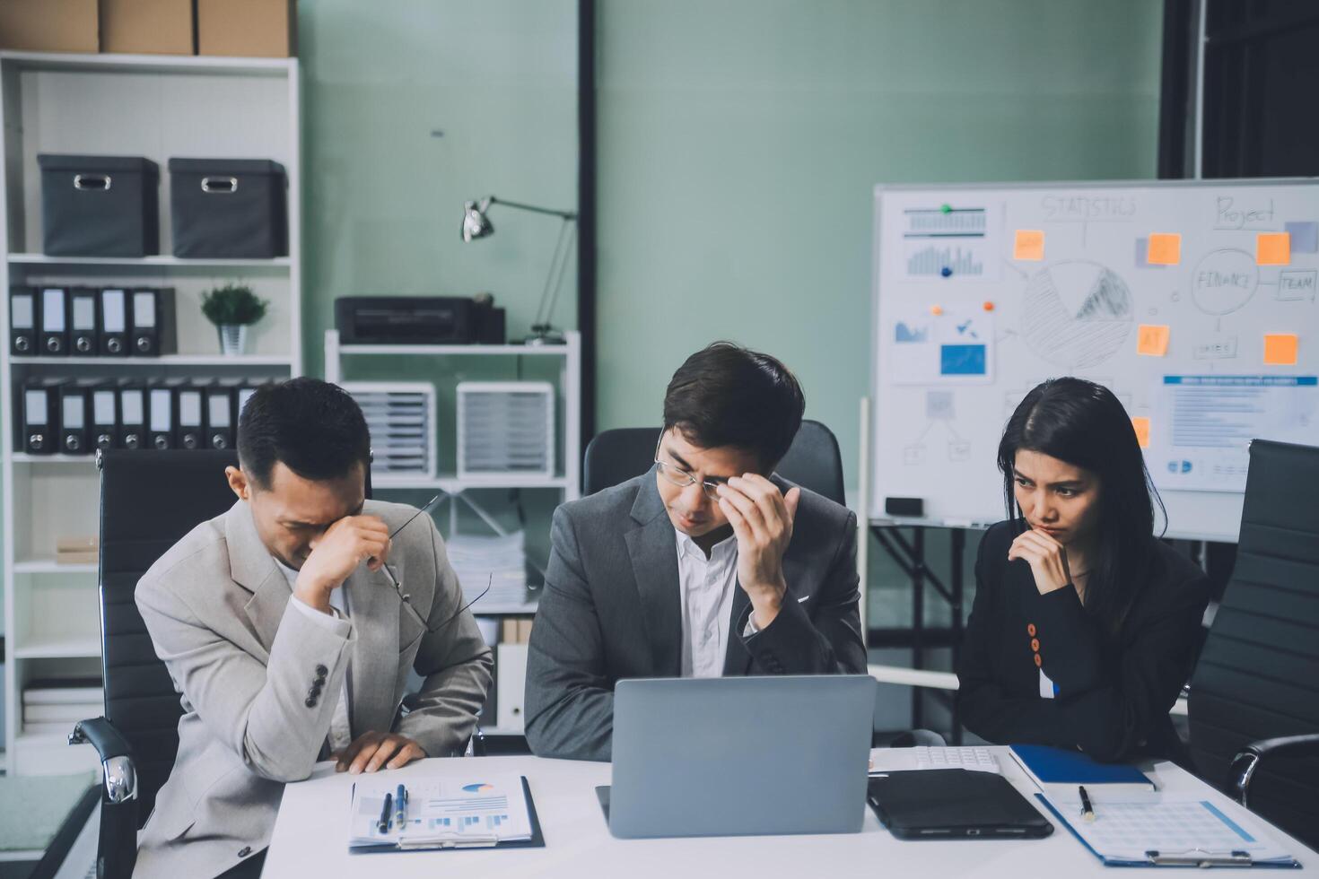 Group of colleagues engaging in a discussion during a business meeting in a conference room. Happy business people, men and women, collaborating and working towards their shared goals. photo