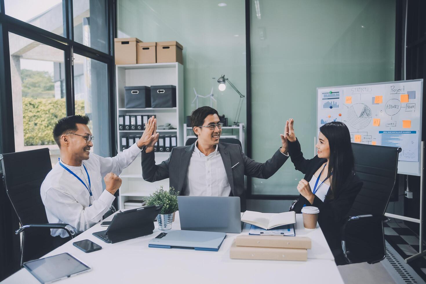 Group of colleagues engaging in a discussion during a business meeting in a conference room. Happy business people, men and women, collaborating and working towards their shared goals. photo