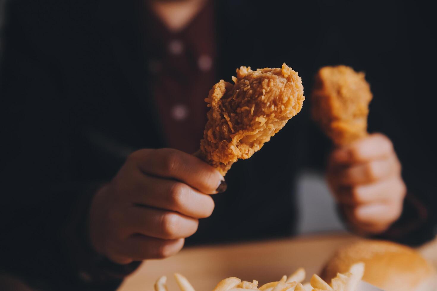 close up focus woman hand hold fried chicken for eat,girl with fast food concept photo