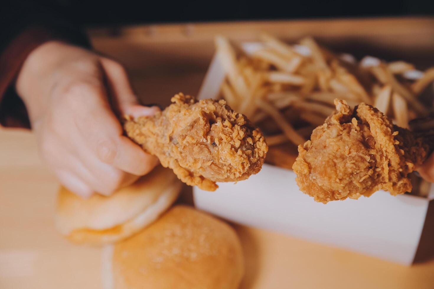 close up focus woman hand hold fried chicken for eat,girl with fast food concept photo