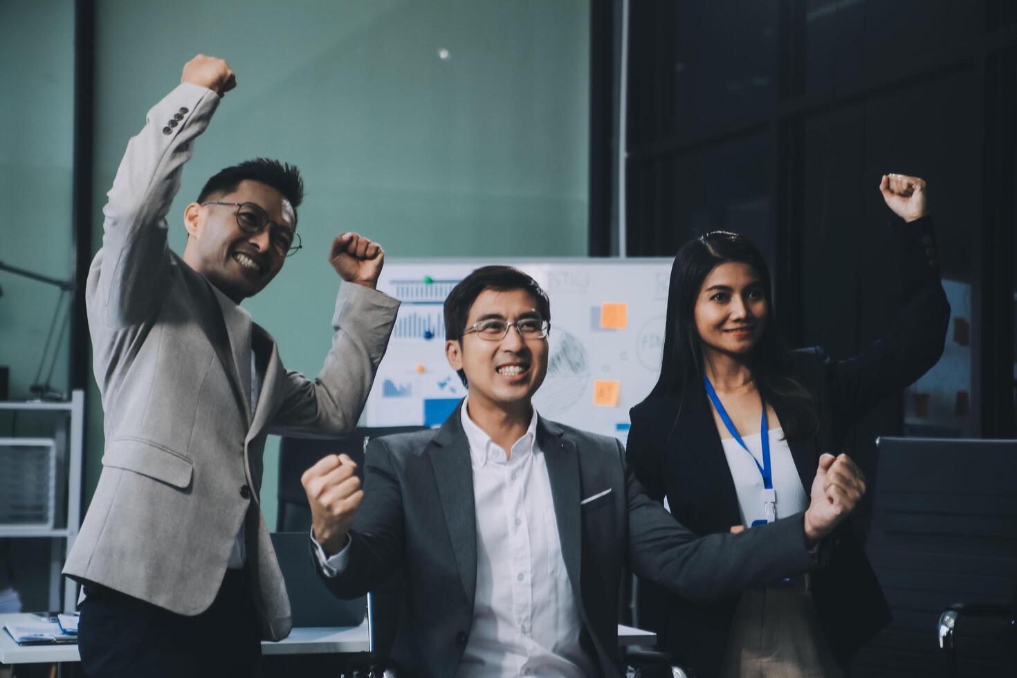 Group of colleagues engaging in a discussion during a business meeting in a conference room. Happy business people, men and women, collaborating and working towards their shared goals. photo