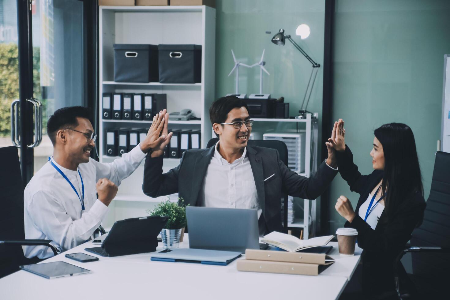 Group of colleagues engaging in a discussion during a business meeting in a conference room. Happy business people, men and women, collaborating and working towards their shared goals. photo