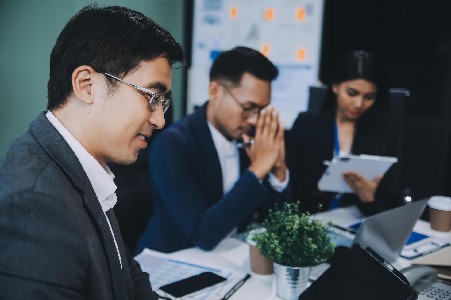 Group of colleagues engaging in a discussion during a business meeting in a conference room. Happy business people, men and women, collaborating and working towards their shared goals. photo