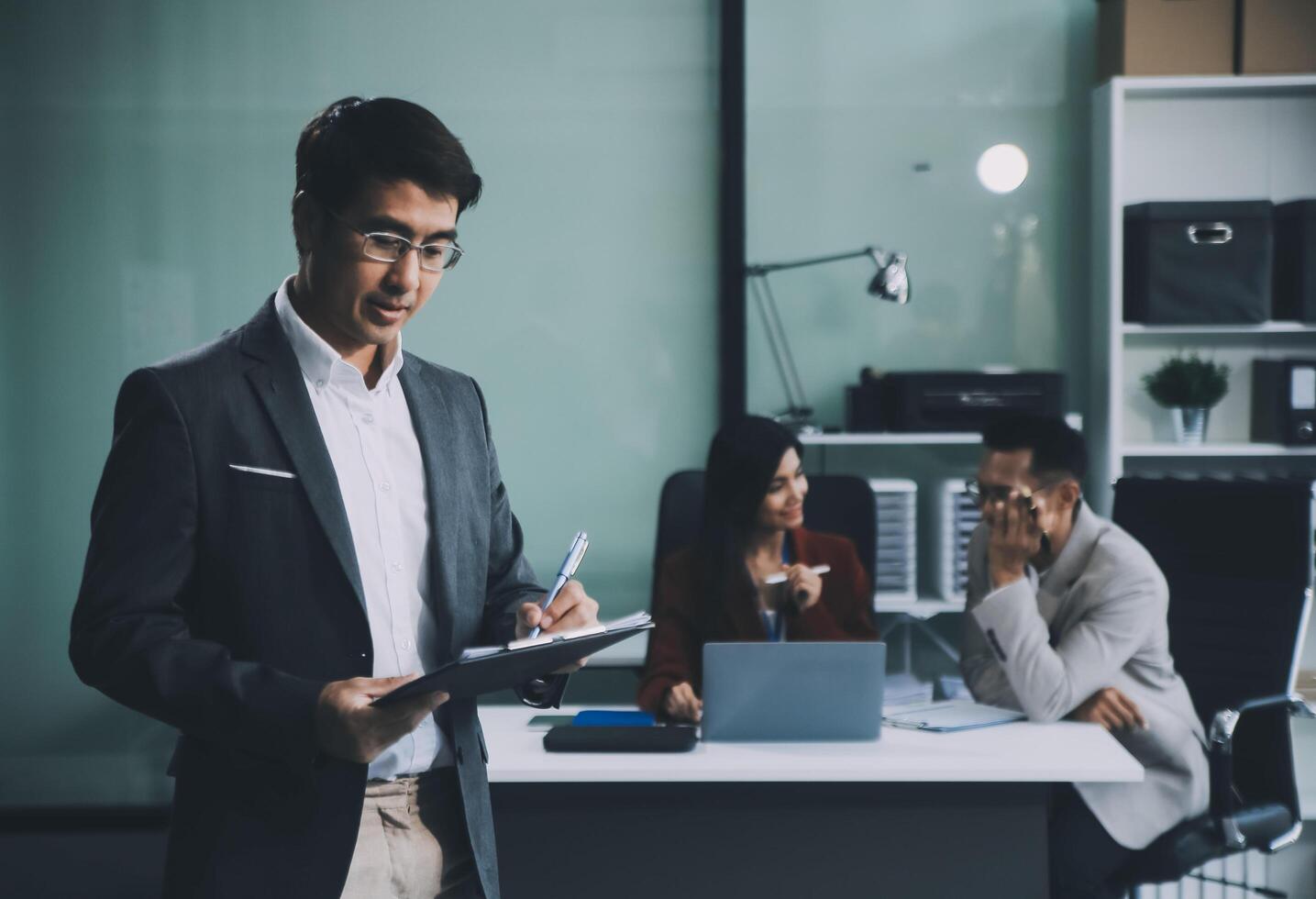 Group of colleagues engaging in a discussion during a business meeting in a conference room. Happy business people, men and women, collaborating and working towards their shared goals. photo