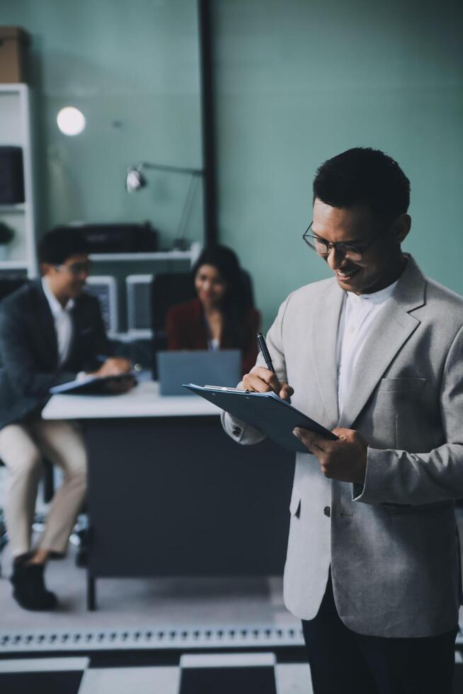 Group of colleagues engaging in a discussion during a business meeting in a conference room. Happy business people, men and women, collaborating and working towards their shared goals. photo
