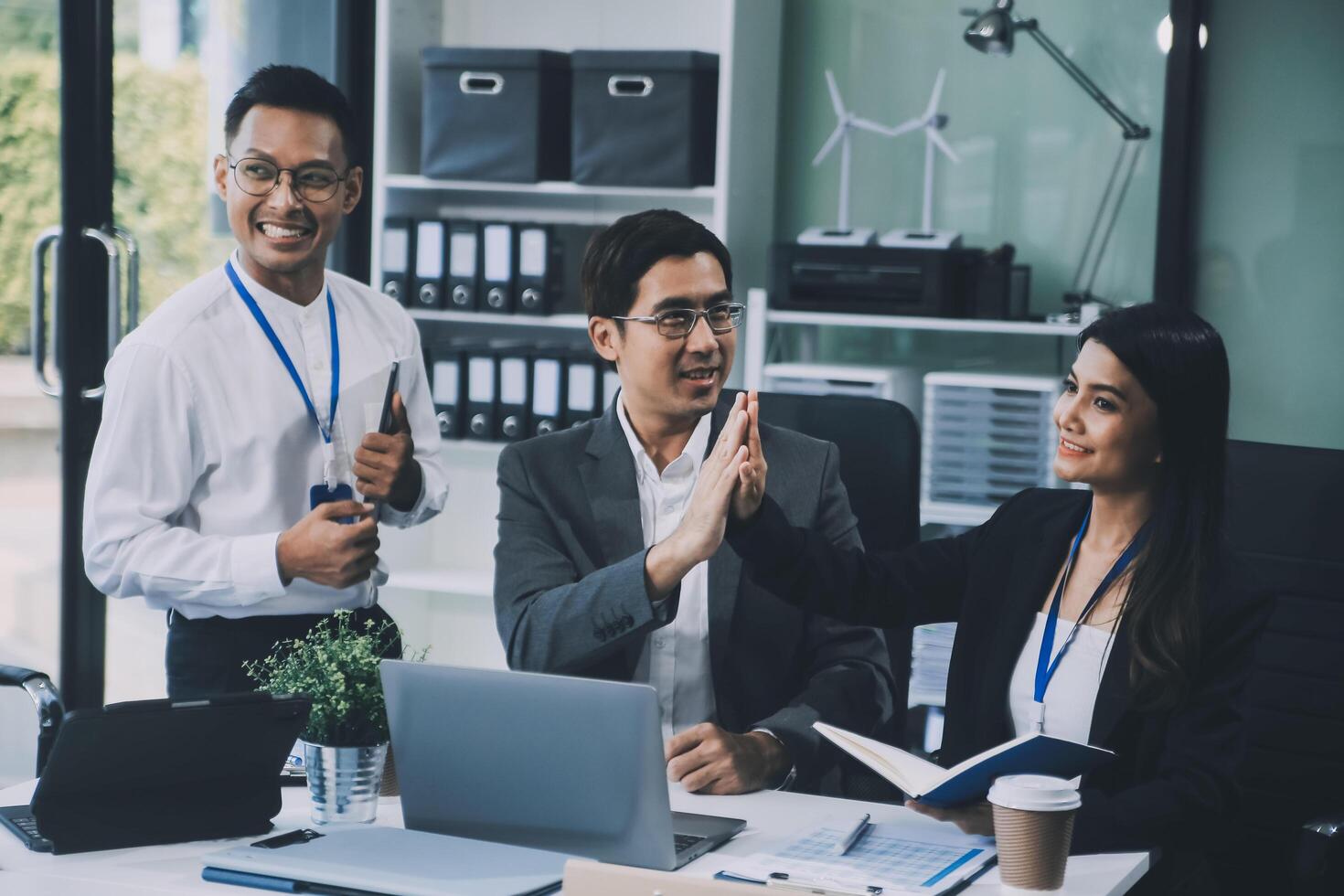 Group of colleagues engaging in a discussion during a business meeting in a conference room. Happy business people, men and women, collaborating and working towards their shared goals. photo