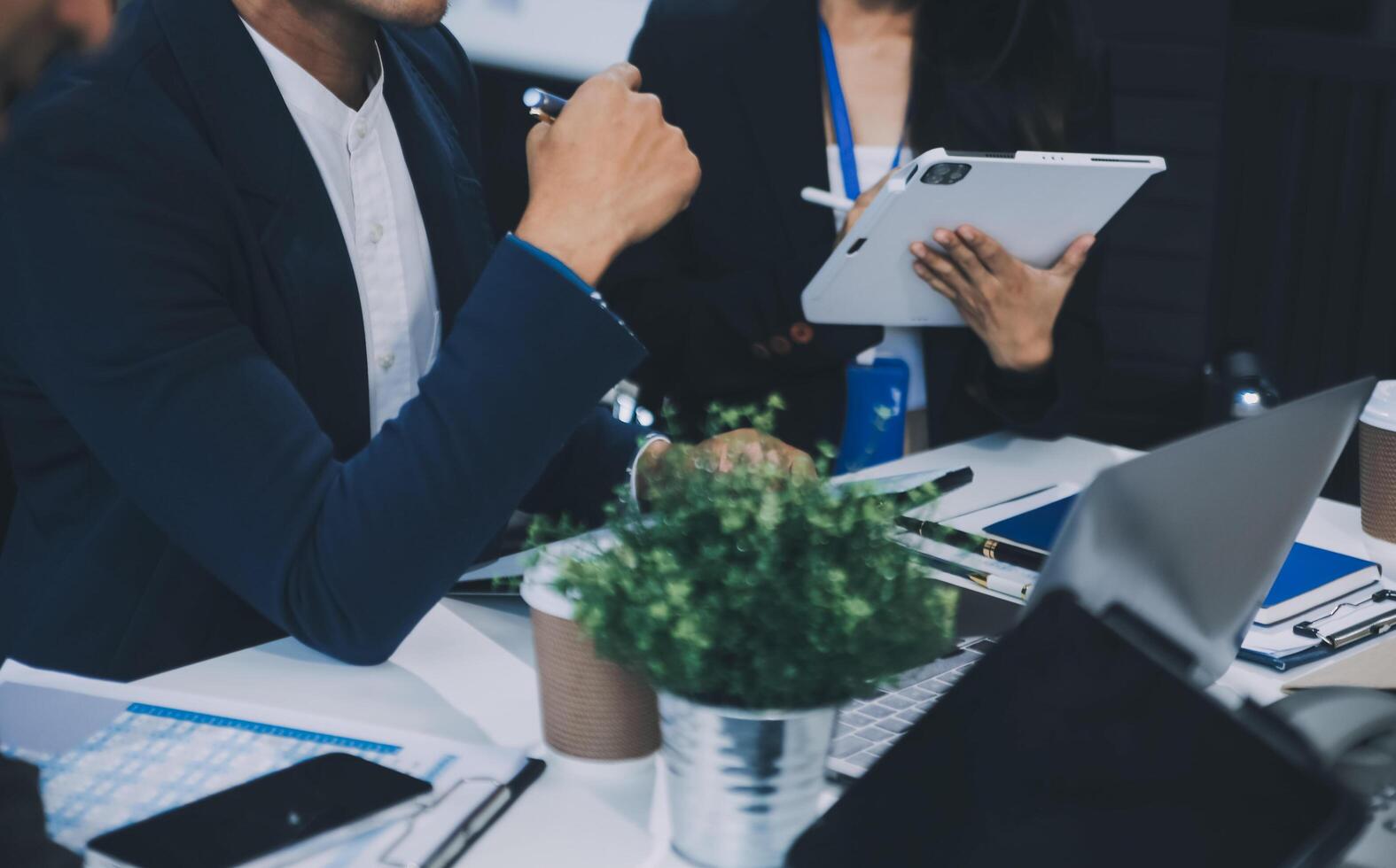 Group of colleagues engaging in a discussion during a business meeting in a conference room. Happy business people, men and women, collaborating and working towards their shared goals. photo