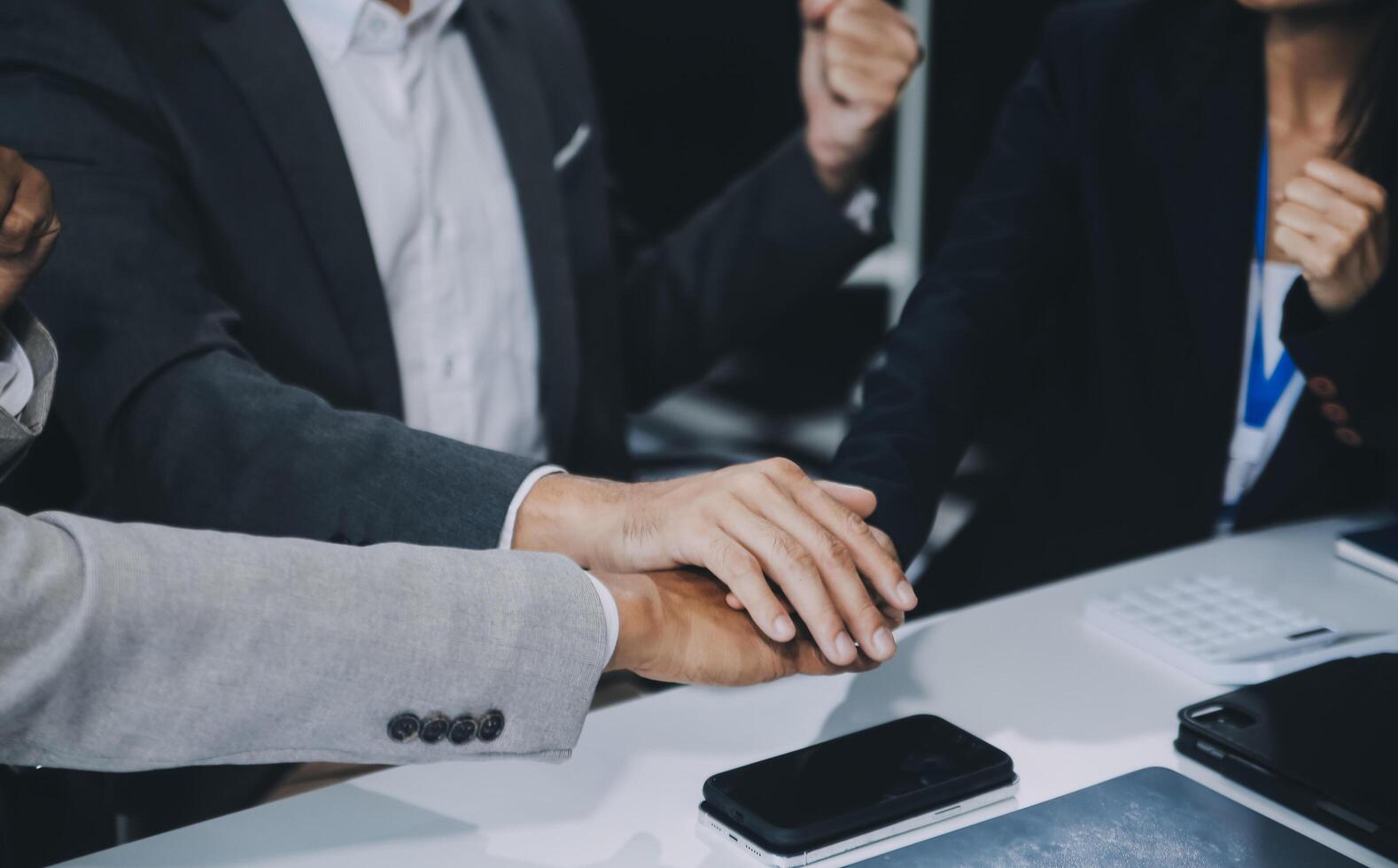 Group of colleagues engaging in a discussion during a business meeting in a conference room. Happy business people, men and women, collaborating and working towards their shared goals. photo