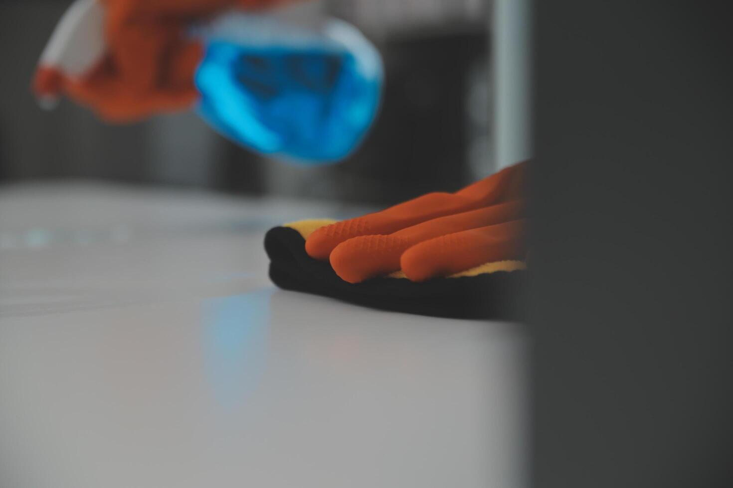 Woman cleaning table using rag and diffuser at home. photo