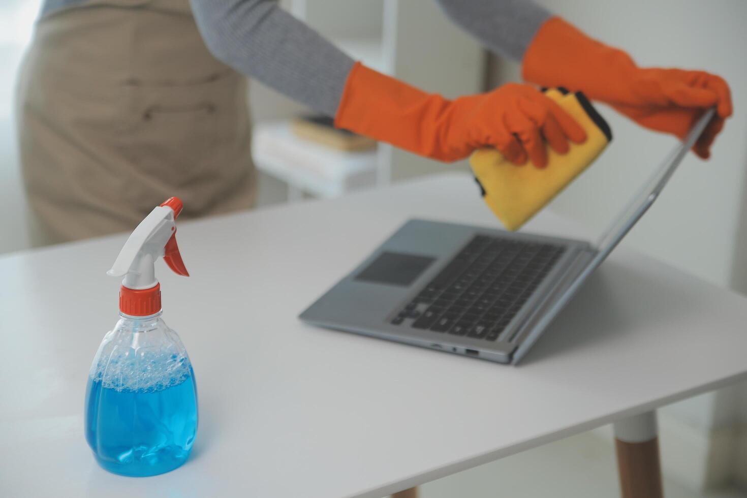 Woman cleaning table using rag and diffuser at home. photo