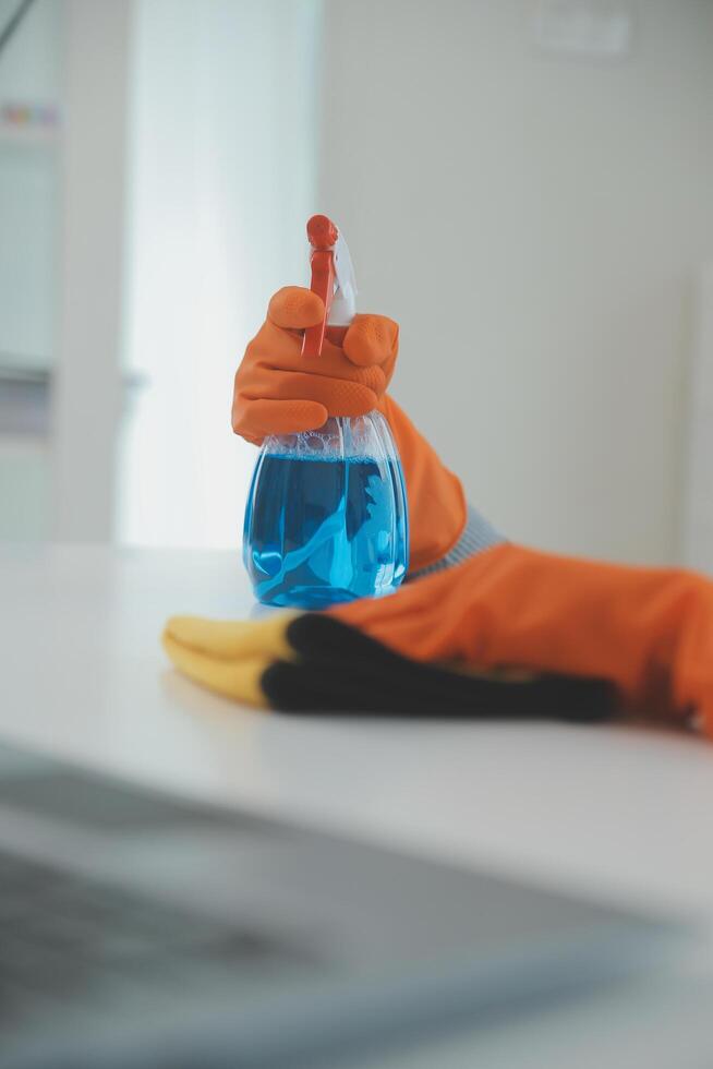 Woman cleaning table using rag and diffuser at home. photo