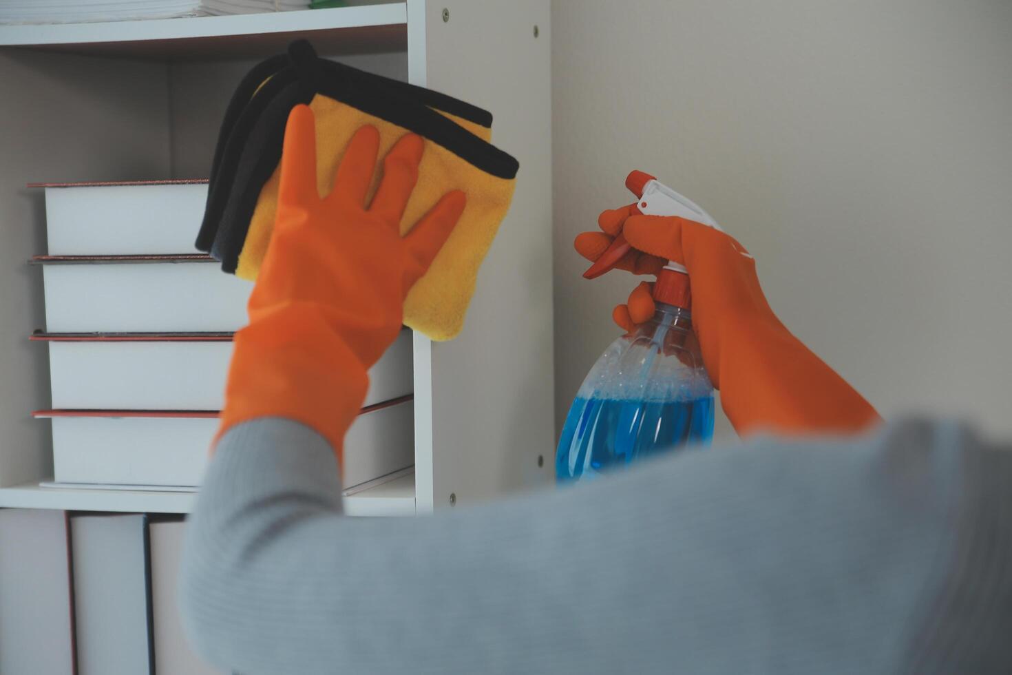 Woman cleaning table using rag and diffuser at home. photo