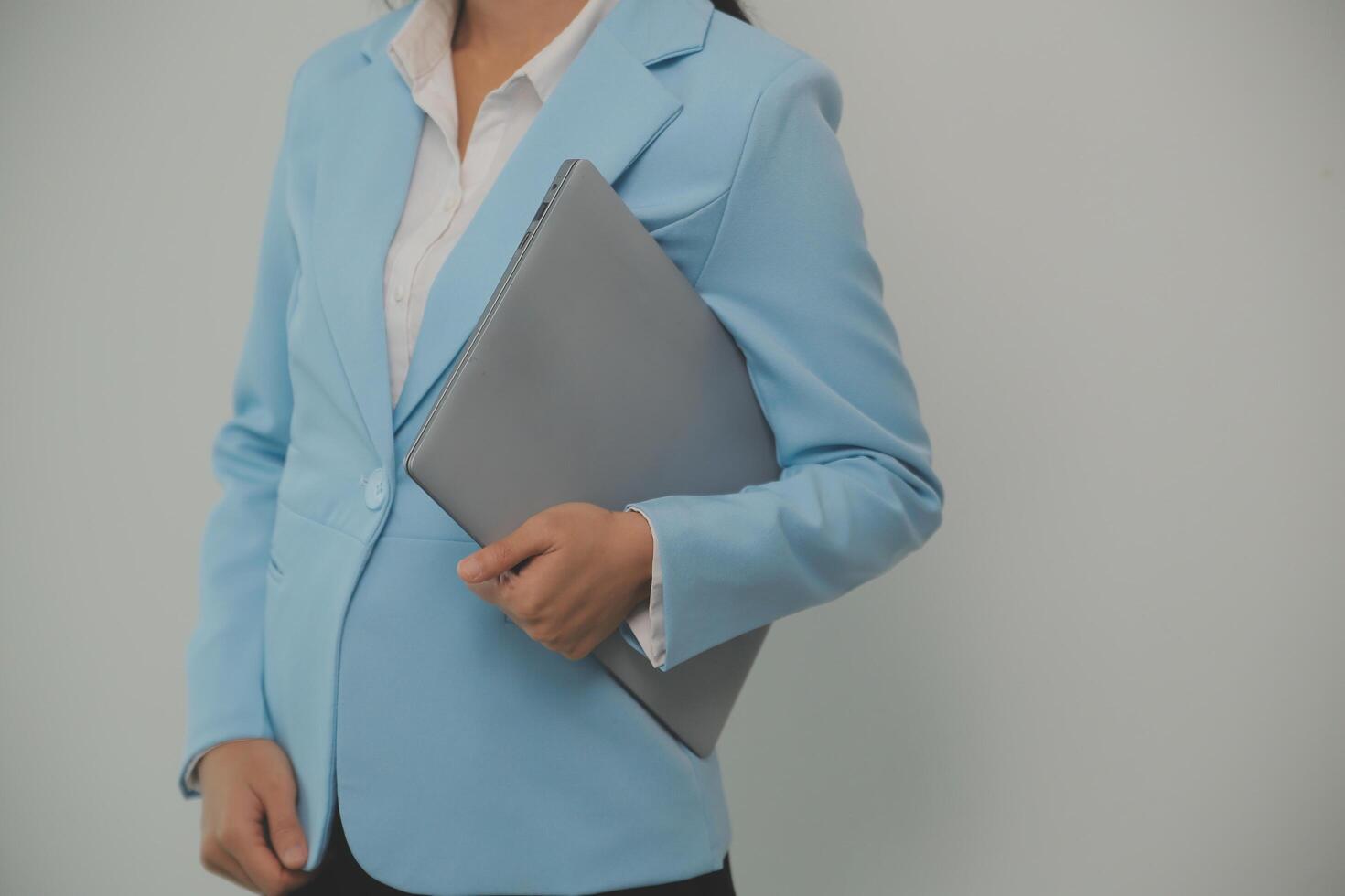 Portrait of a happy asian businesswoman working on laptop computer isolated over white background photo
