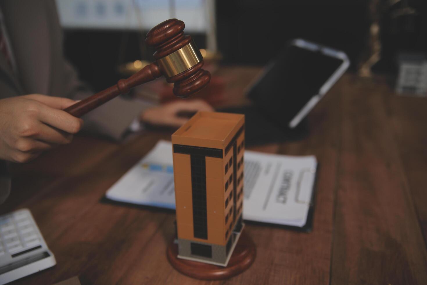 Real Estate Law, Home Insurance, property Tax, Auction and Bidding concepts. small toy house model with gavel justice hammer on desk in courthouse. photo