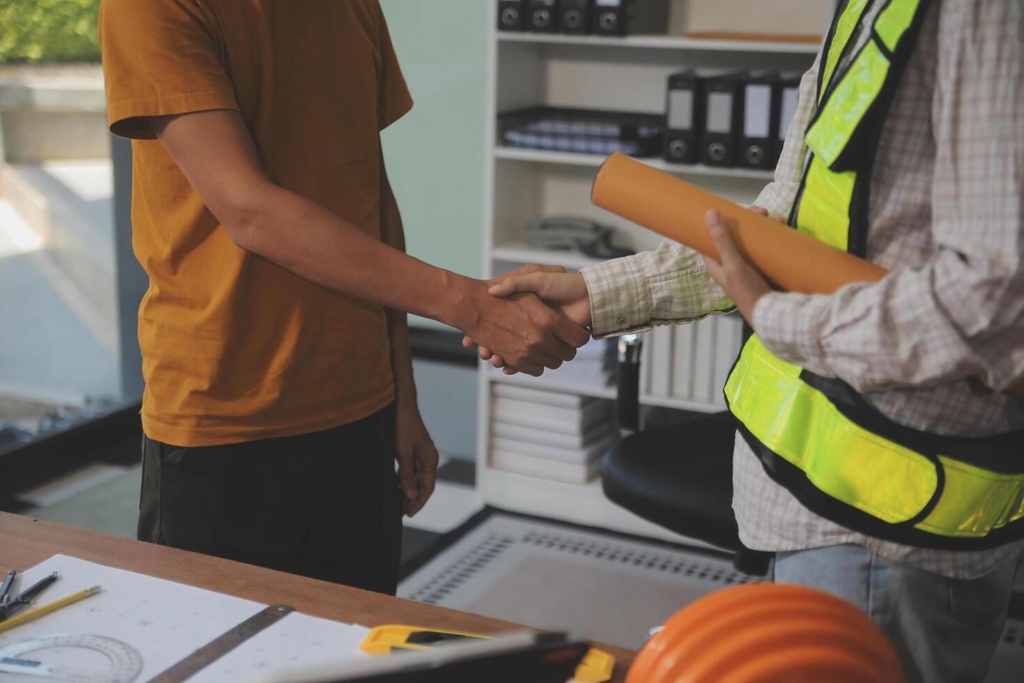 Architect men making handshake in construction site. Employee or worker shake hands to employer man for greeting, dealing, teamwork, collaboration some project or business. They are good team photo