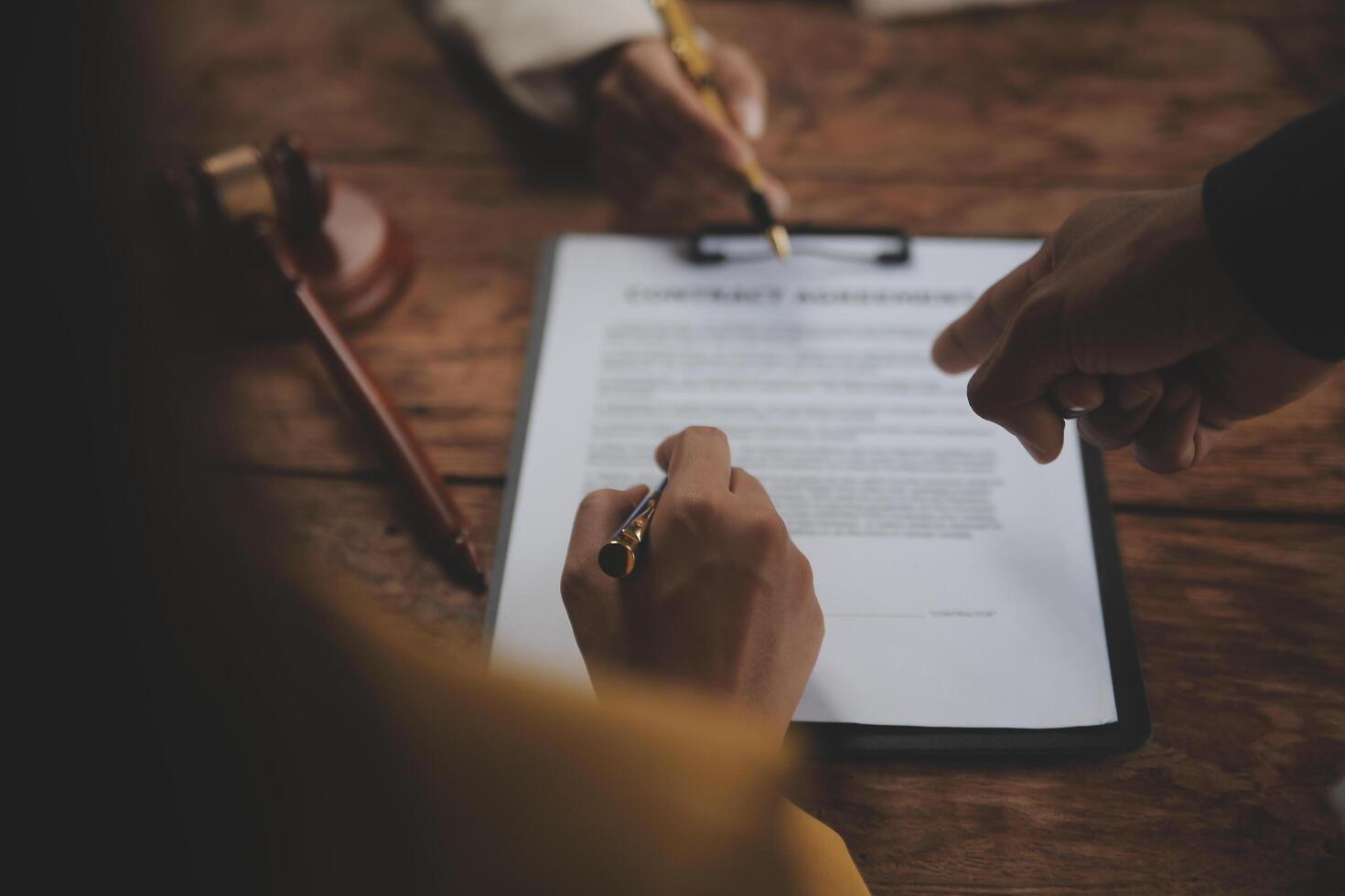 Business and lawyers discussing contract papers with brass scale on desk in office. Law, legal services, advice, justice and law concept picture with film grain effect photo